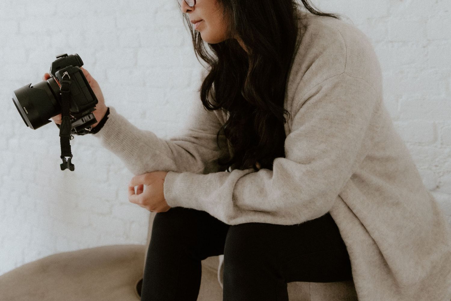 Photographer holding camera with glasses in black and white portrait. Photo of Savvy, business owner of Savvy Photography