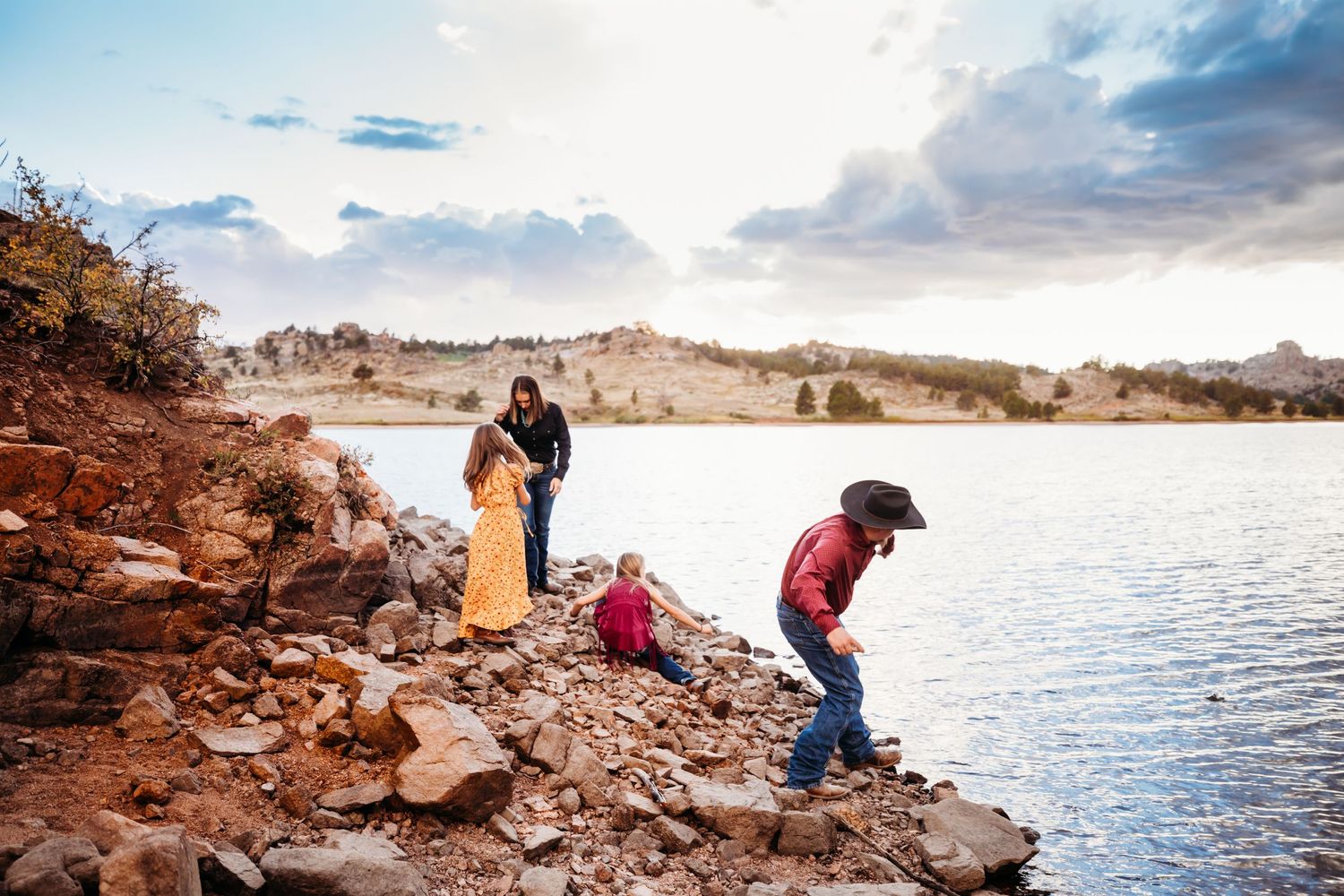 Family with mom, dad, and kids playing at a lake surrounded by mountains in Cheyenne, WY