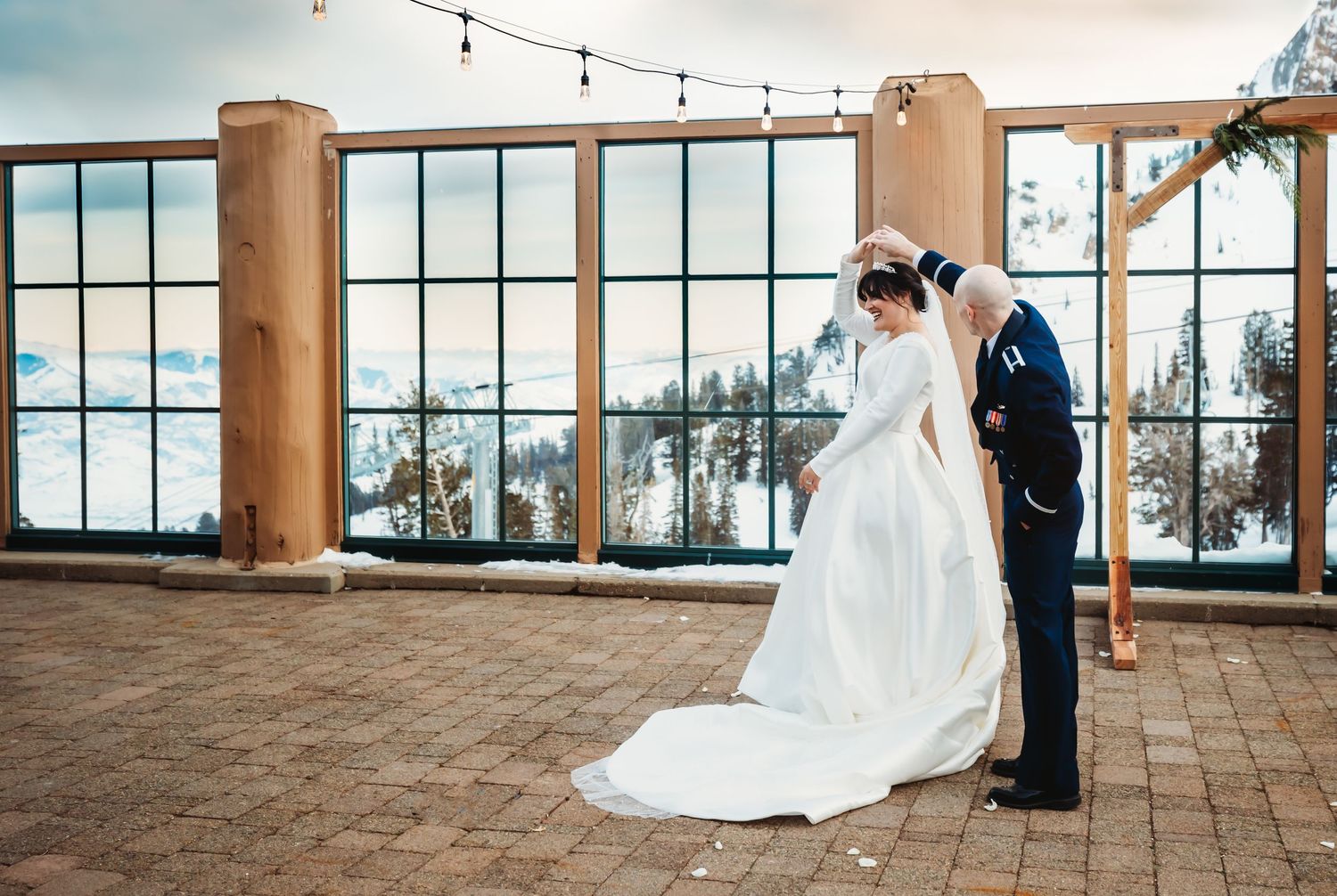 Bride and groom dancing with snowy mountains in the background in Utah