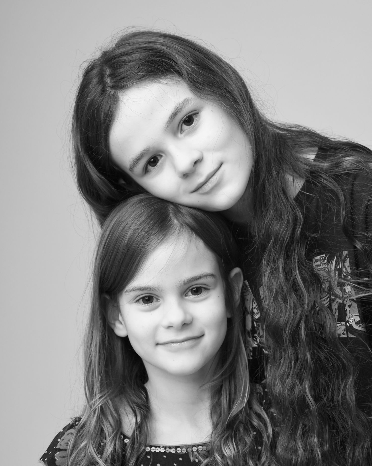 Black and white portrait of two young children posing together, taken by Abigail's Studio, a family photographer in High Wycombe.