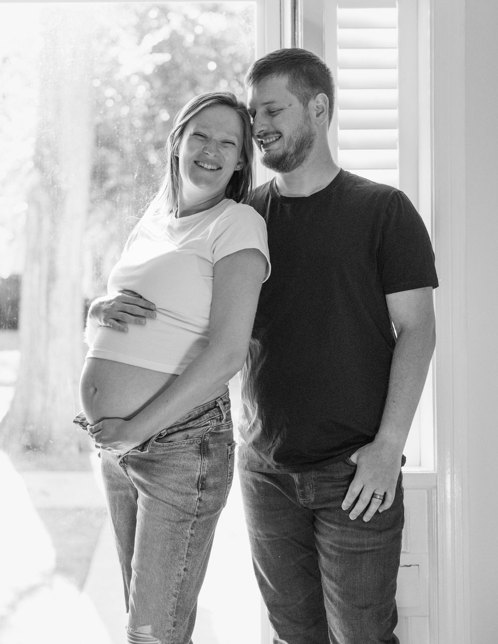 Hannah and David embracing during their in-home maternity session in Flint, Michigan