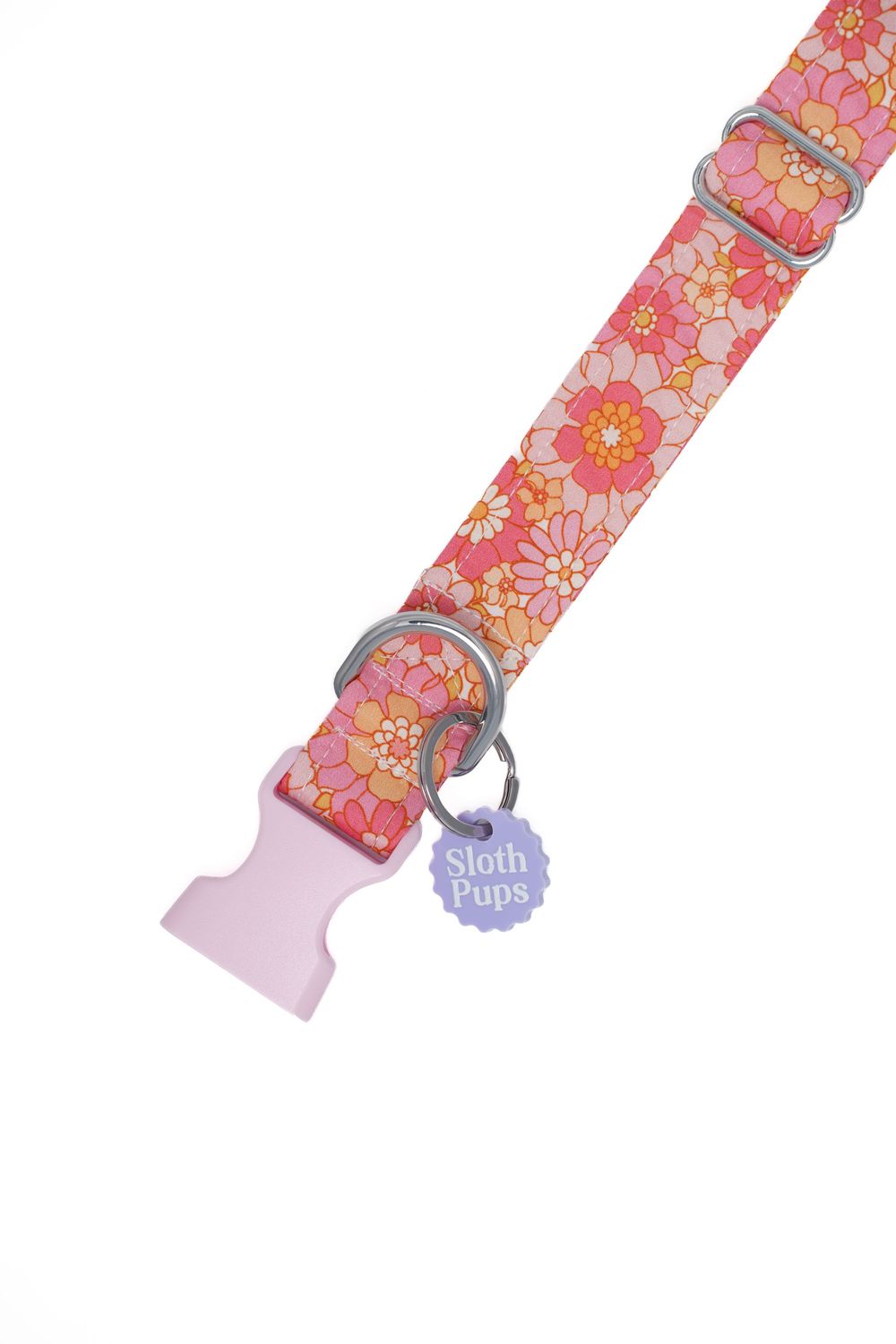 Pink floral dog collar with silver hardware and lavender Sloth Pups charm tag on white background.
