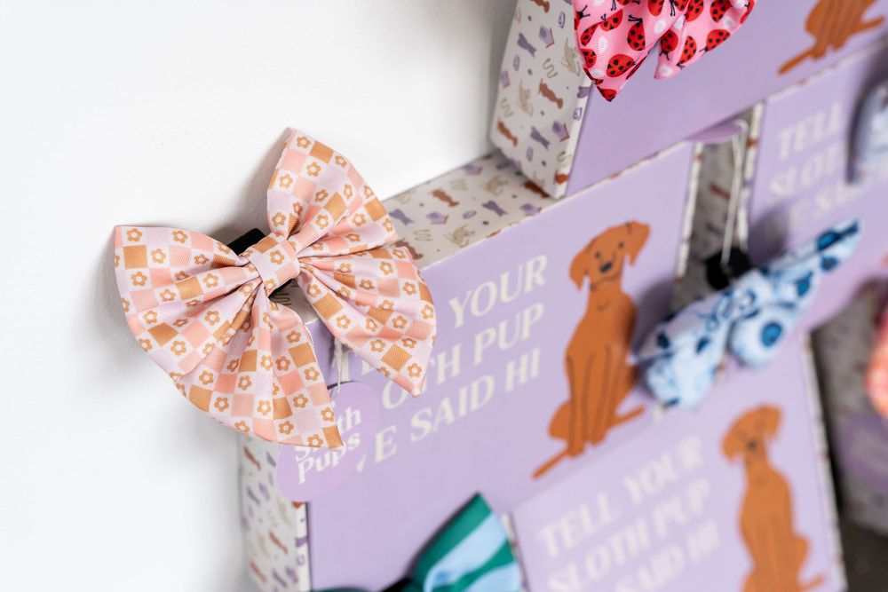 Close-up of a decorative dog-themed advent calendar box with a pink floral bow and illustrated golden retriever designs.
