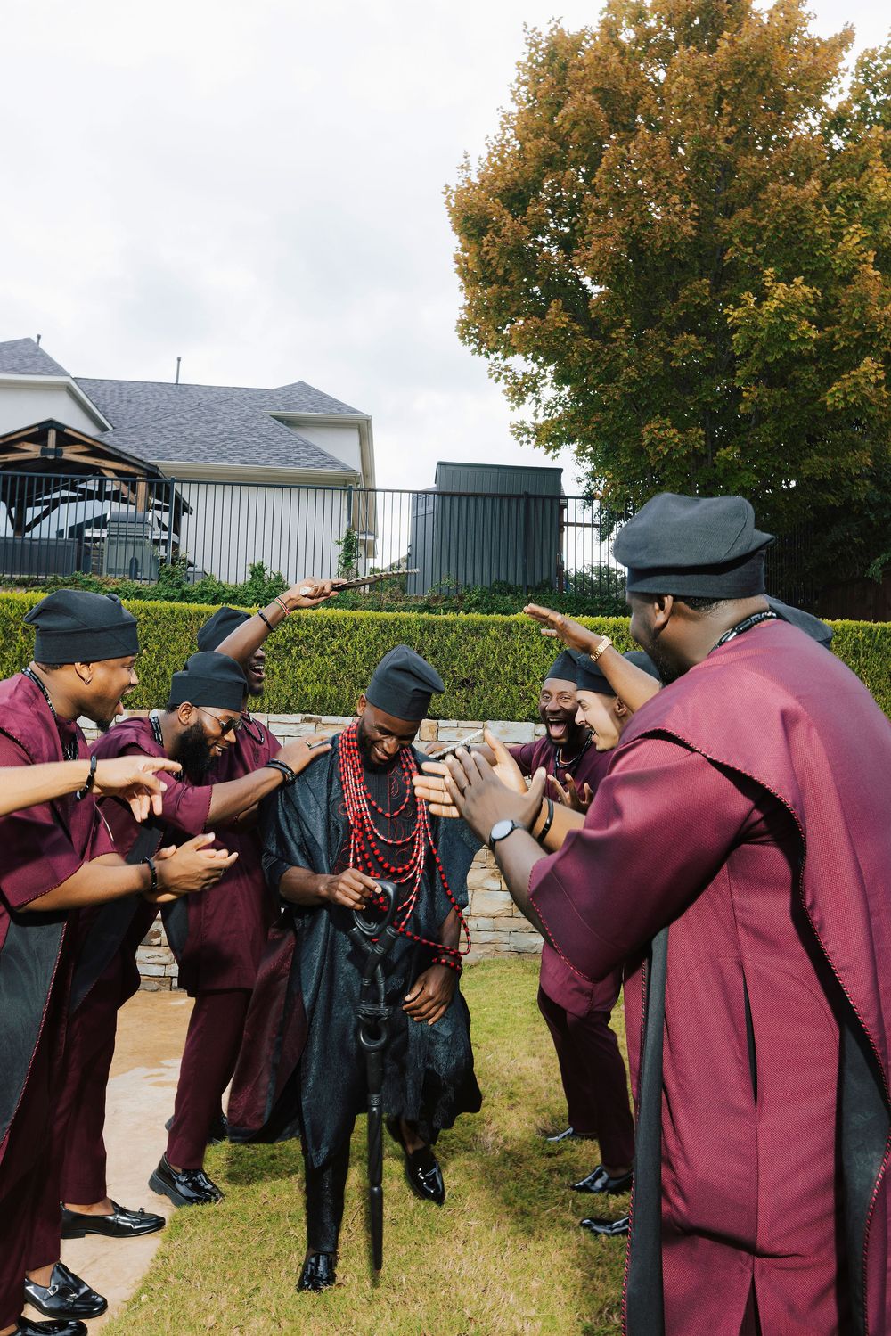 Men in traditional Nigerian attire gather outdoors in a ceremonial circle during a cultural celebration.