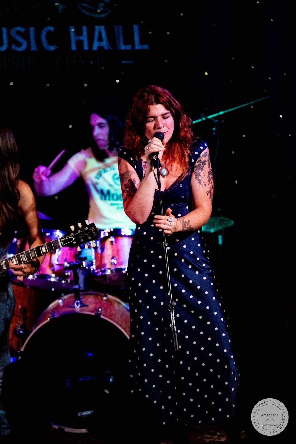 Female singer in polka dot dress performs on stage at The Gem Music Hall.