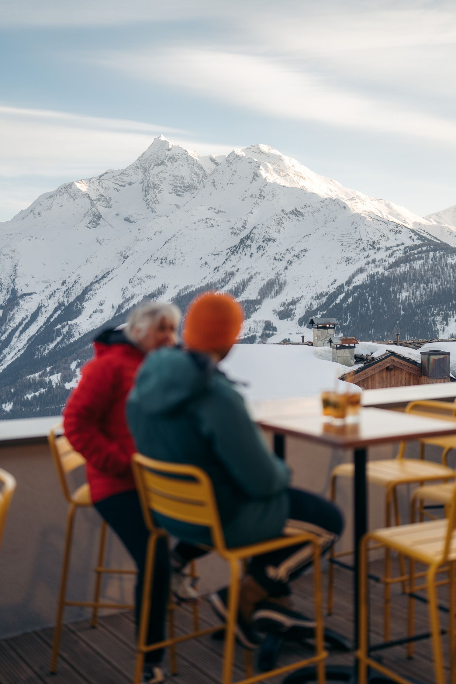 deux personnes boivent un verre en terrasse de la résidence odalys l'ecrin blanc de la rosière