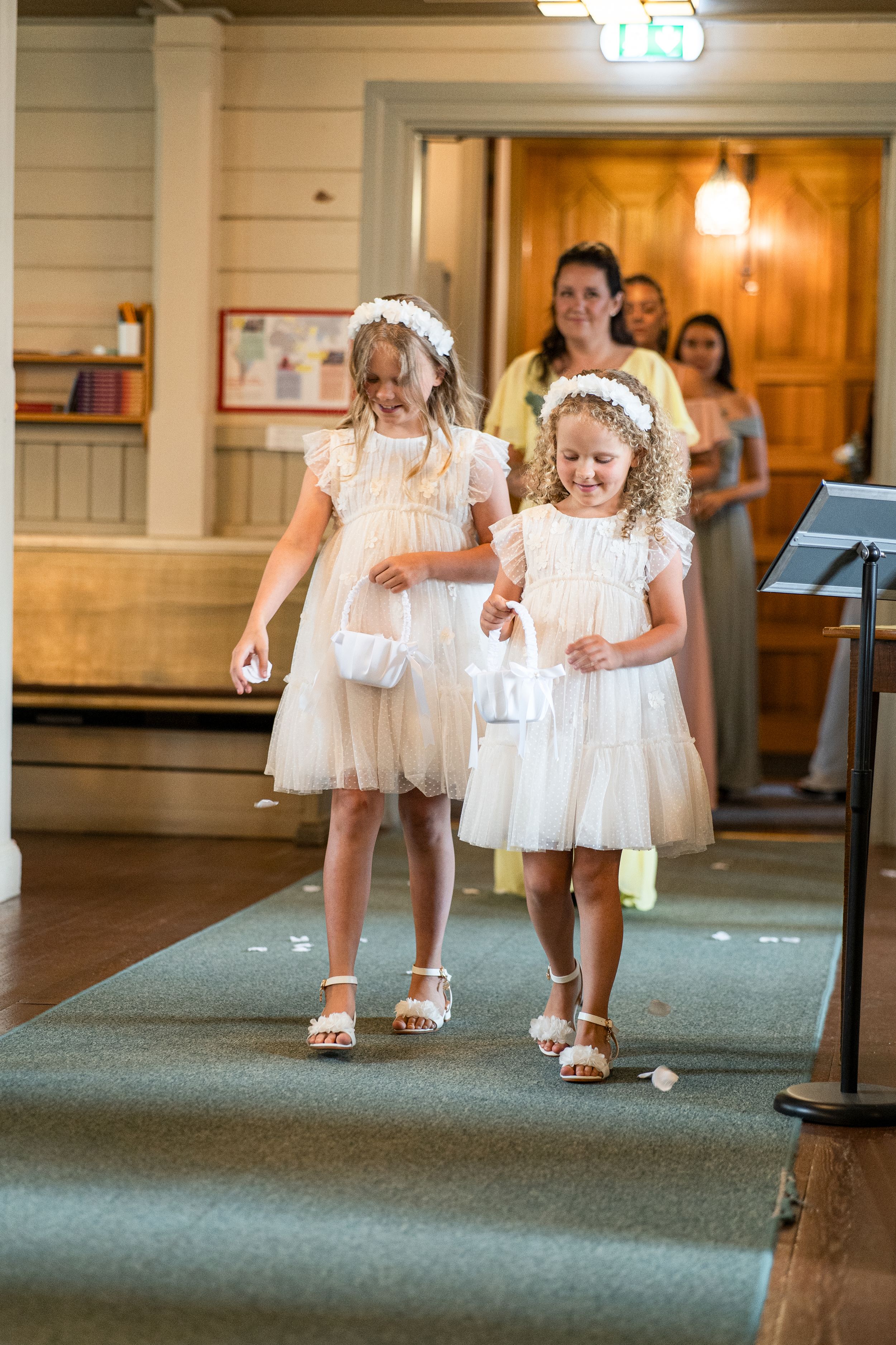 Blomsterflickor på intåg i kyrkan under bröllopsfotografering