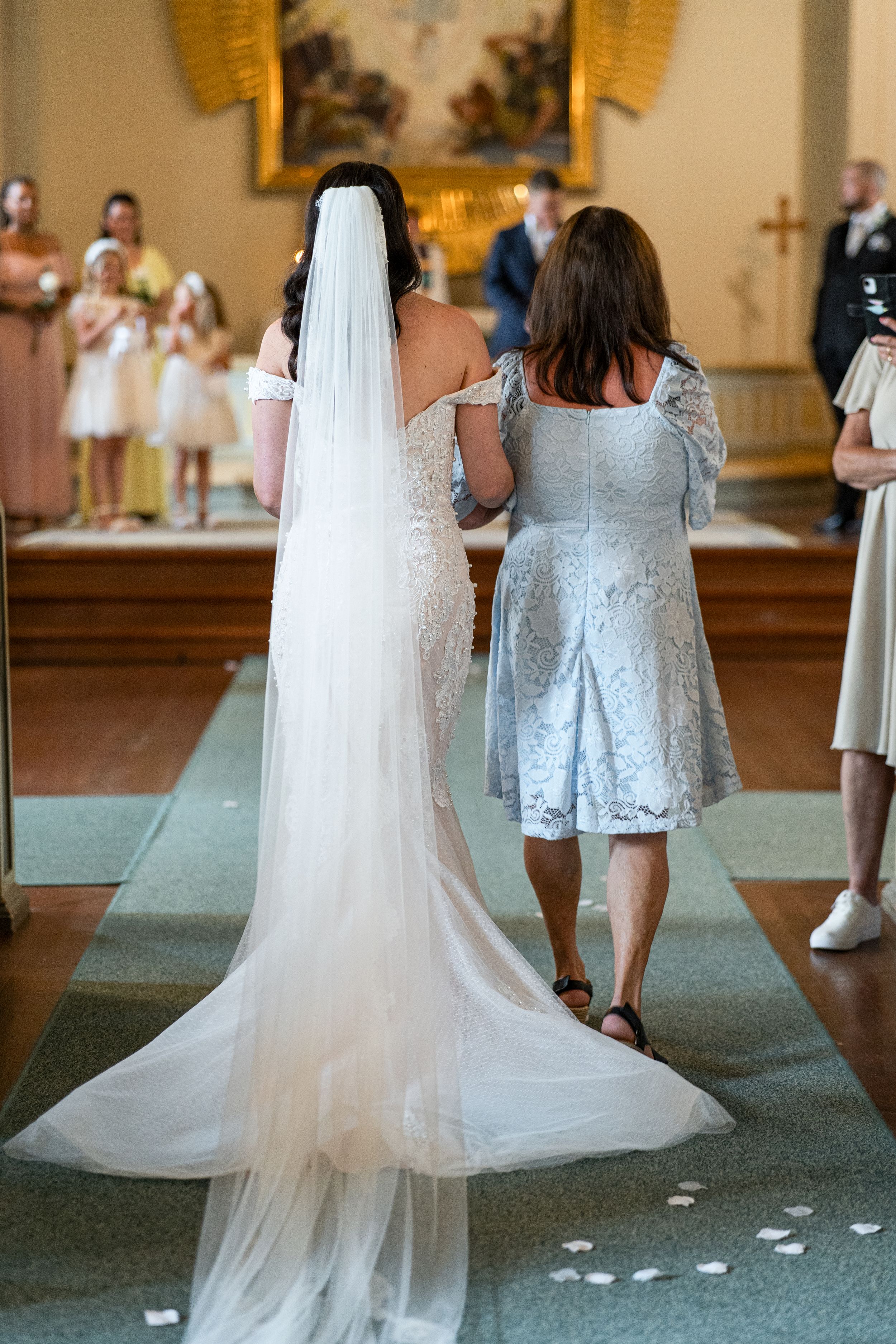 Bruden på väg in i Järbo kyrka under bröllopsfotografering