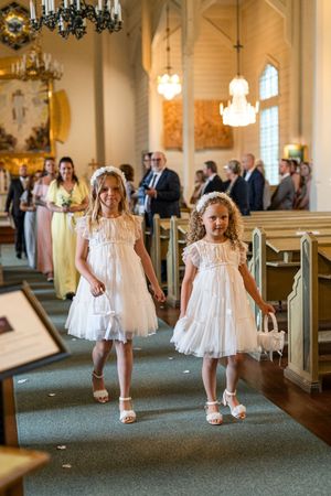 Blomsterflickorna på väg ut ur Järbo kyrka under en bröllopsfotografering i Sandviken