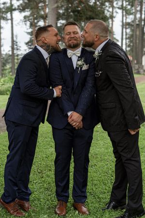 Brudgummen och marskalkarna skojar till det under bröllopsfotograferingen i Sandviken