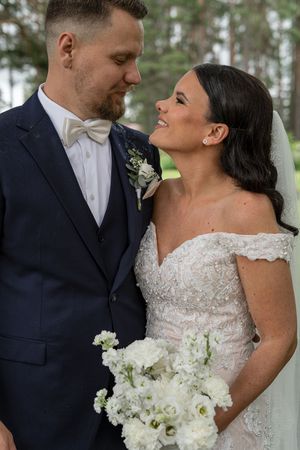 Brudpar ser kärleksfullt på varandra under sin bröllopsfotografering i Järbo, Sandviken