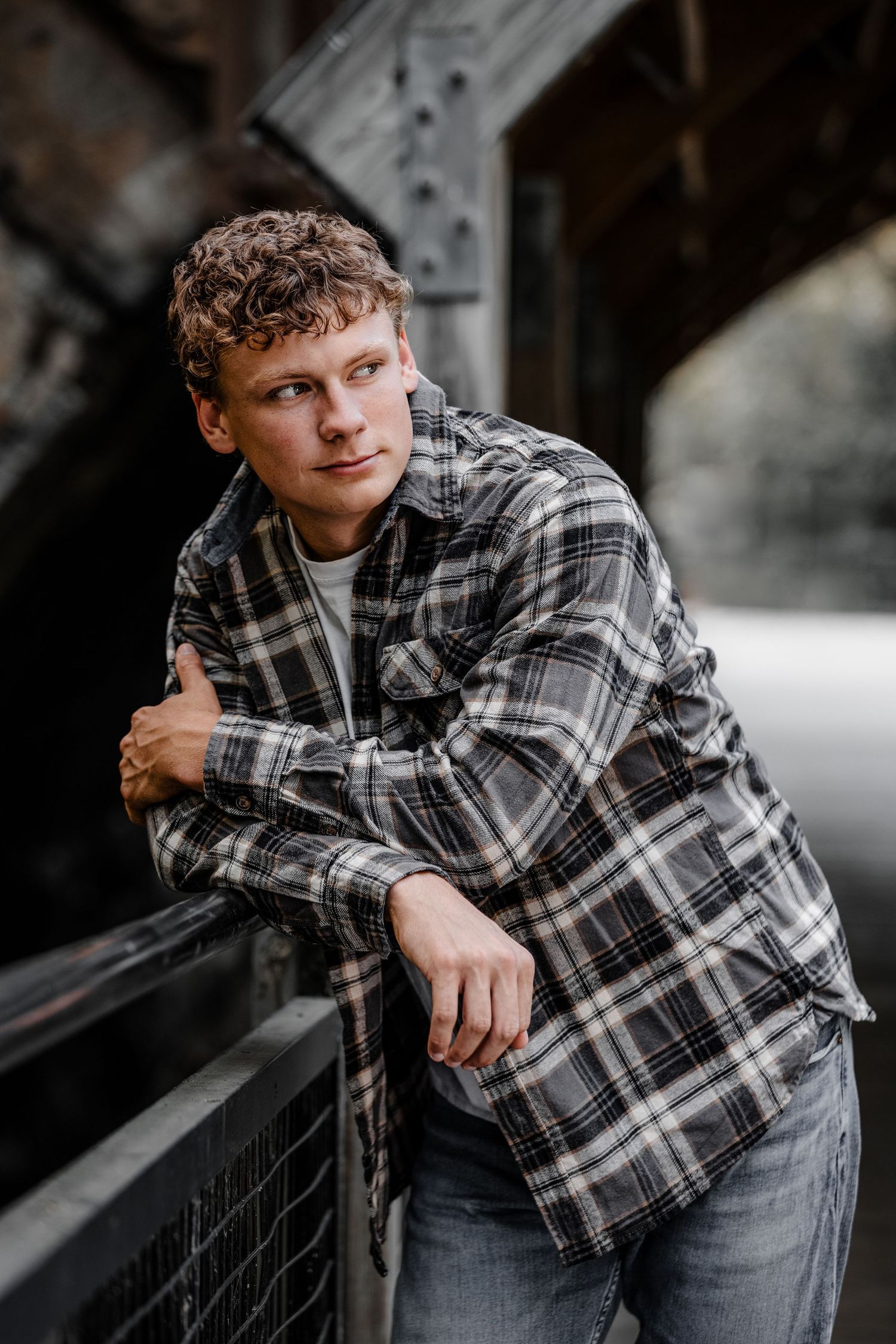 High school senior boy pictures in Dexter park near urban bridge with industrial aesthetic, Michigan by South Lyon portrait photographer
