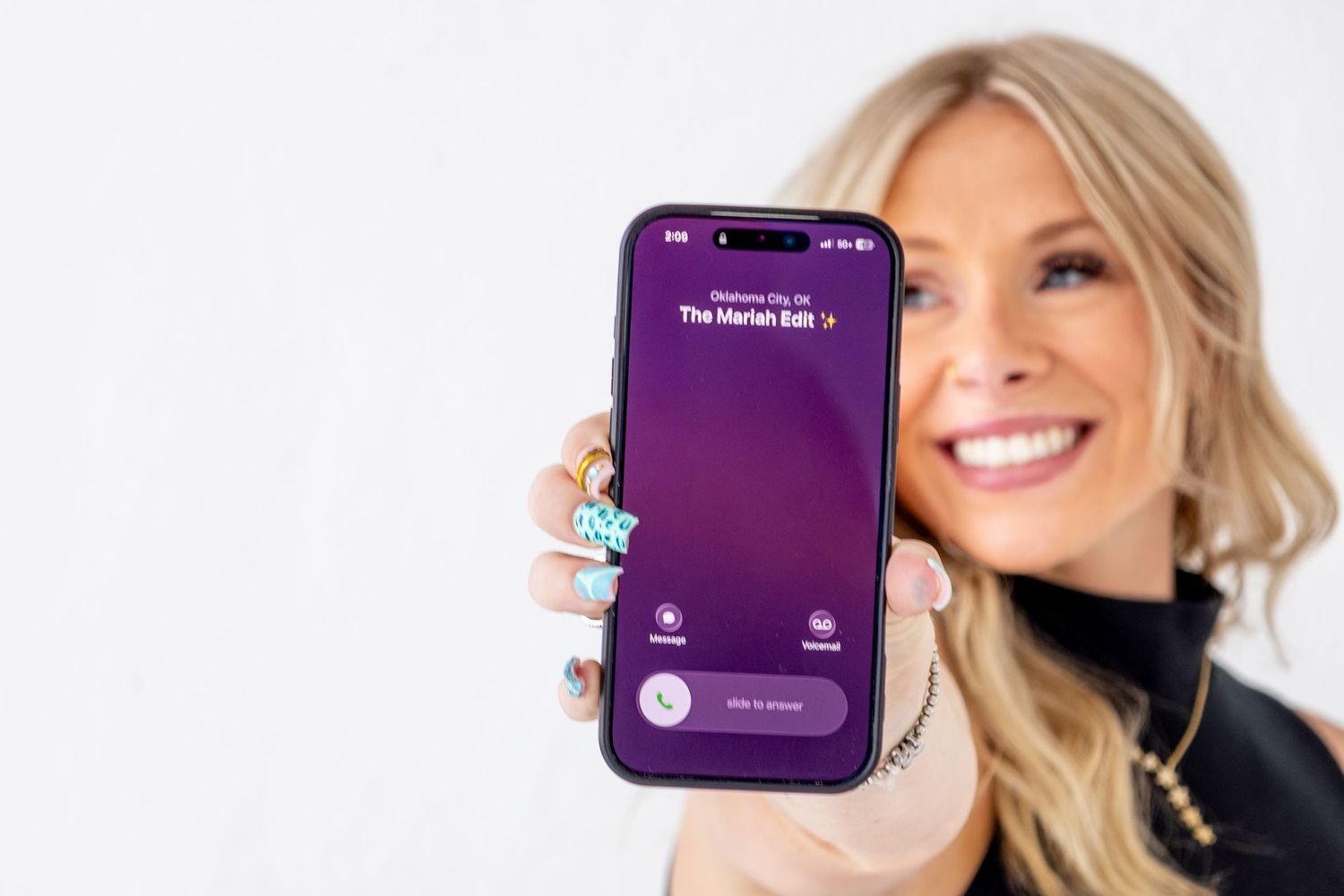 Smiling business owner holding a smartphone during a professional branding photography session.