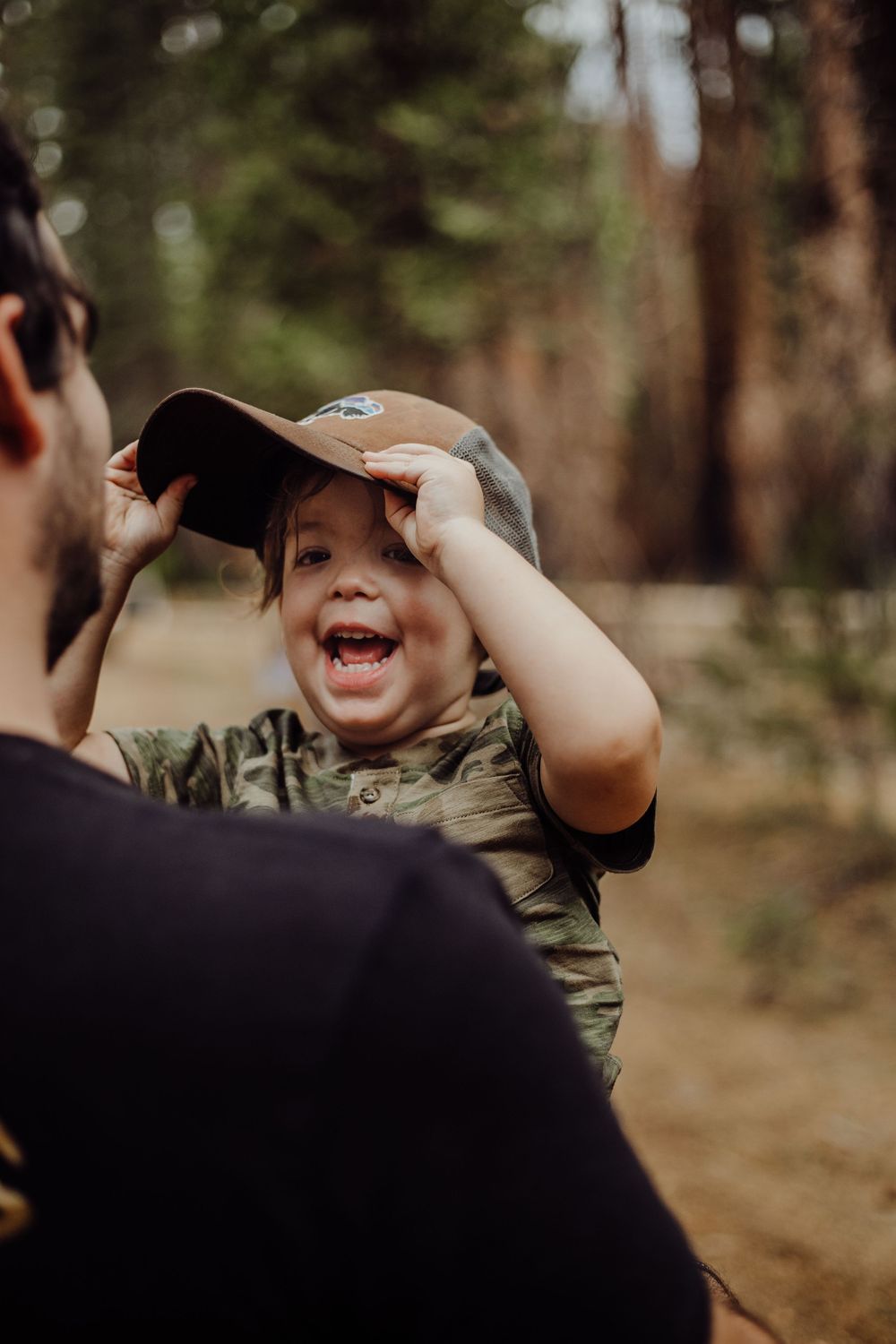 A father and his young son with his son wearing his hat