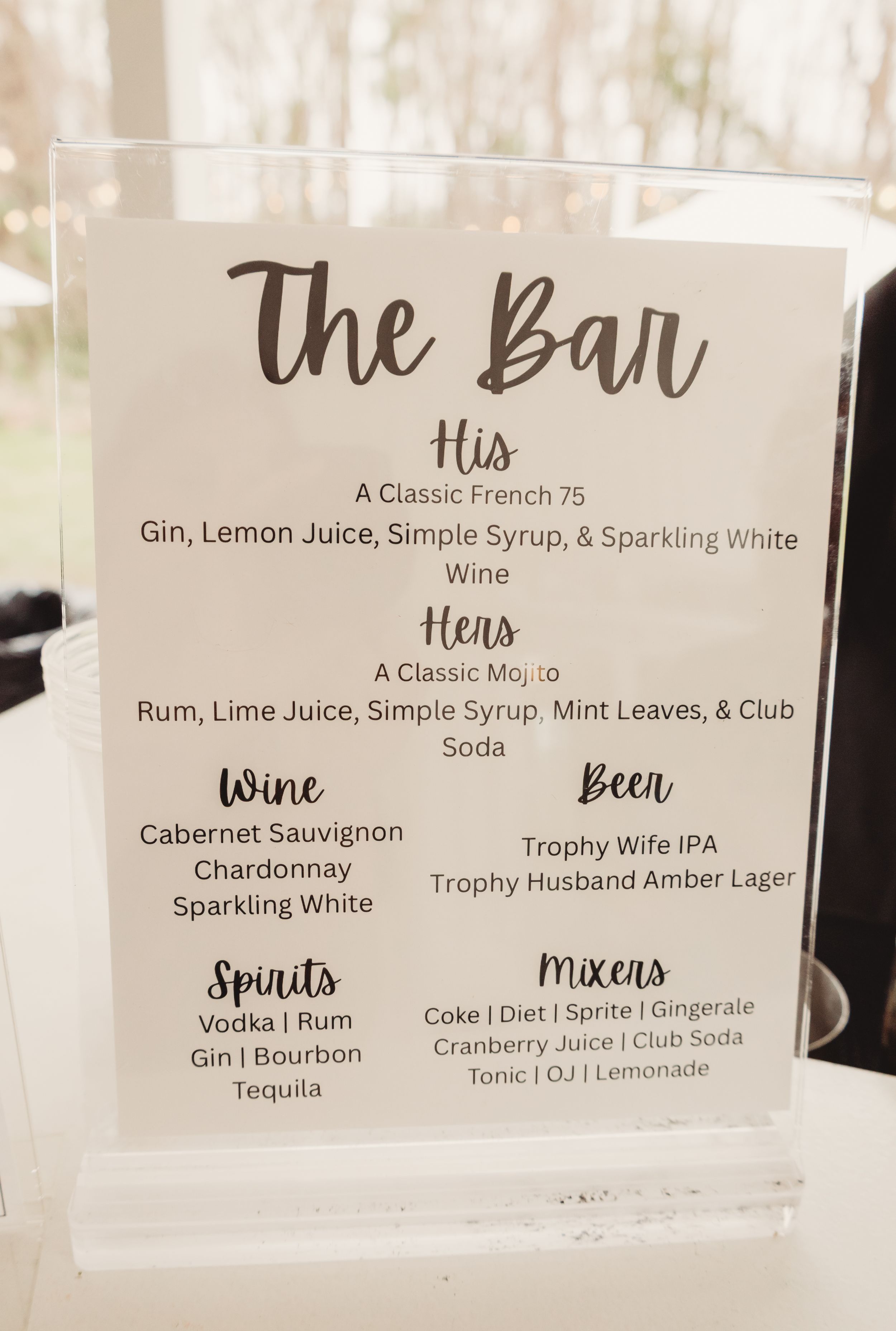 Wedding bar menu sign displaying His and Hers cocktails, wine, beer, spirits, and mixers options for reception.