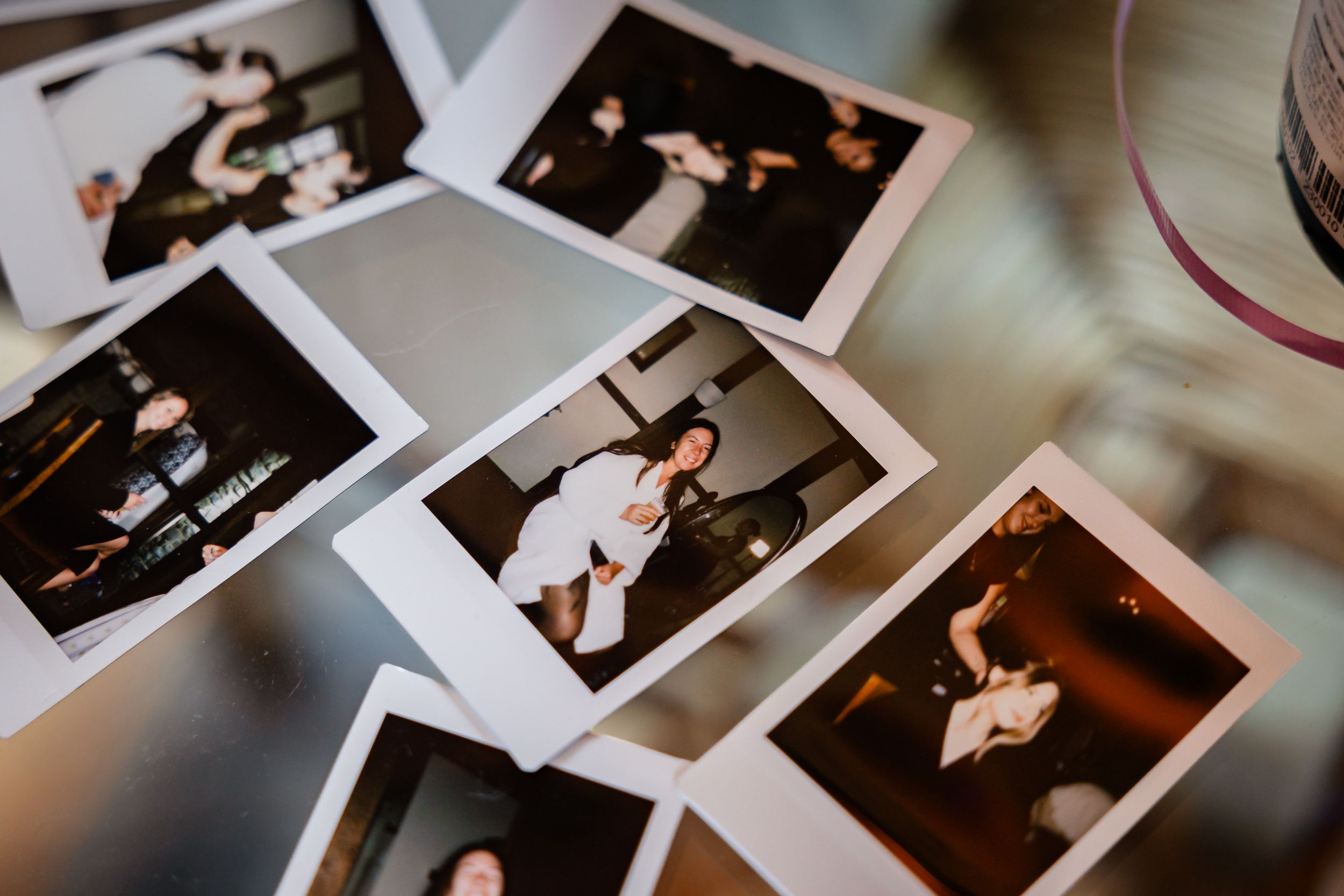 Collection of Polaroid photos spread on table capturing candid wedding reception moments.