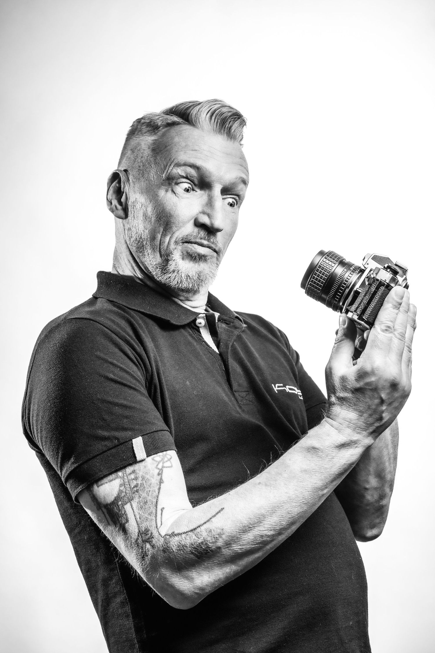 Zelfportret van fotograaf Bart Boodts met Nikon camera, expressief zwart wit portret voor personal branding en LinkedIn profielfoto.
