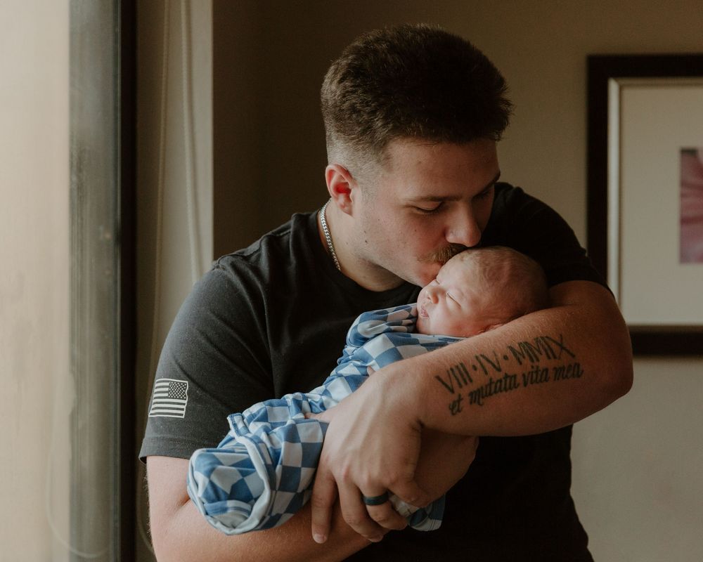 Dad kissing newborn baby during fresh 48 session in Tyler Tx