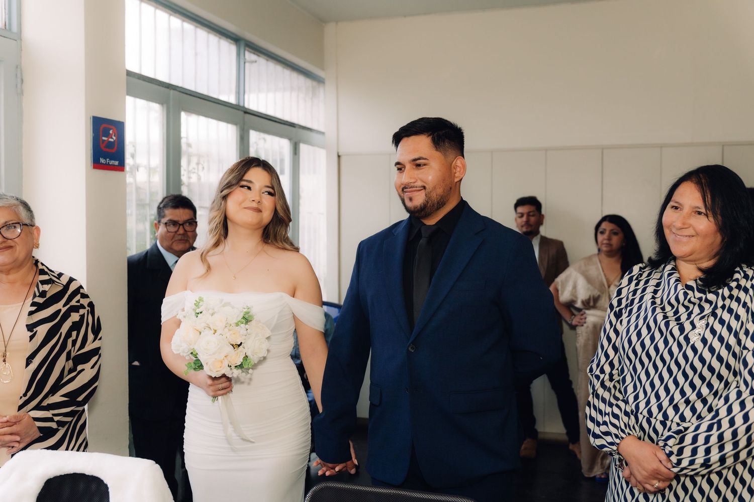 Bride and groom holding hands walking down the aisle at a civil wedding ceremony.