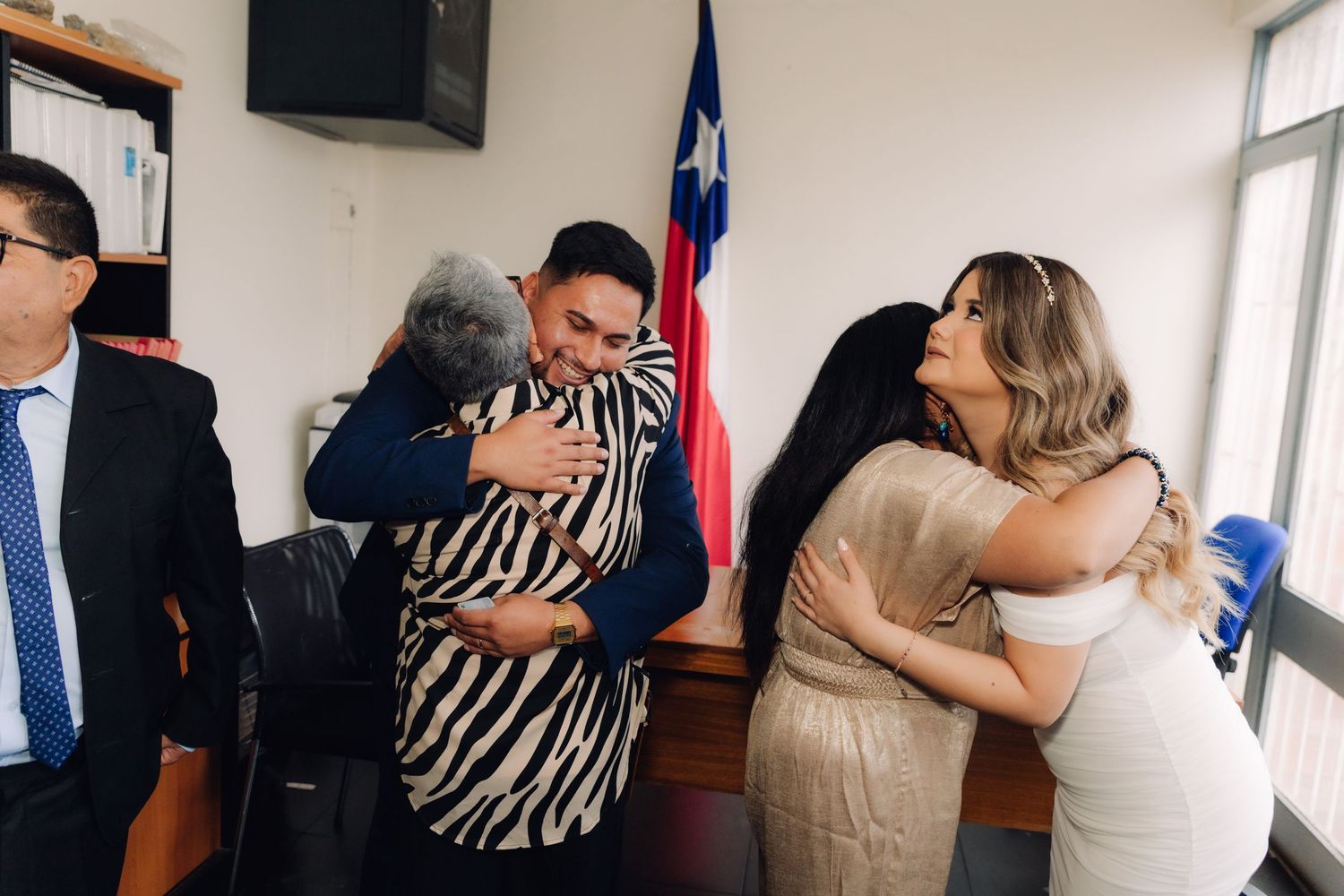 Family members share warm embraces with bride and groom after Chilean civil wedding ceremony.