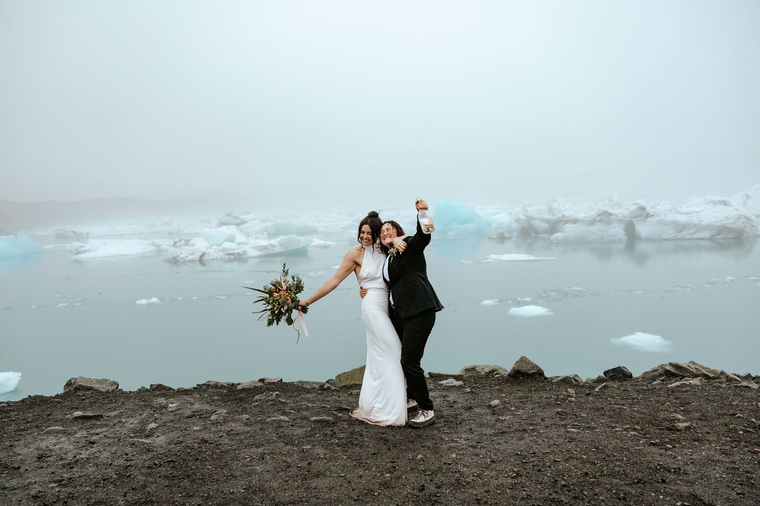 brides cheering after popping champagne at Jokulsarlon glacier lagoon in iceland
