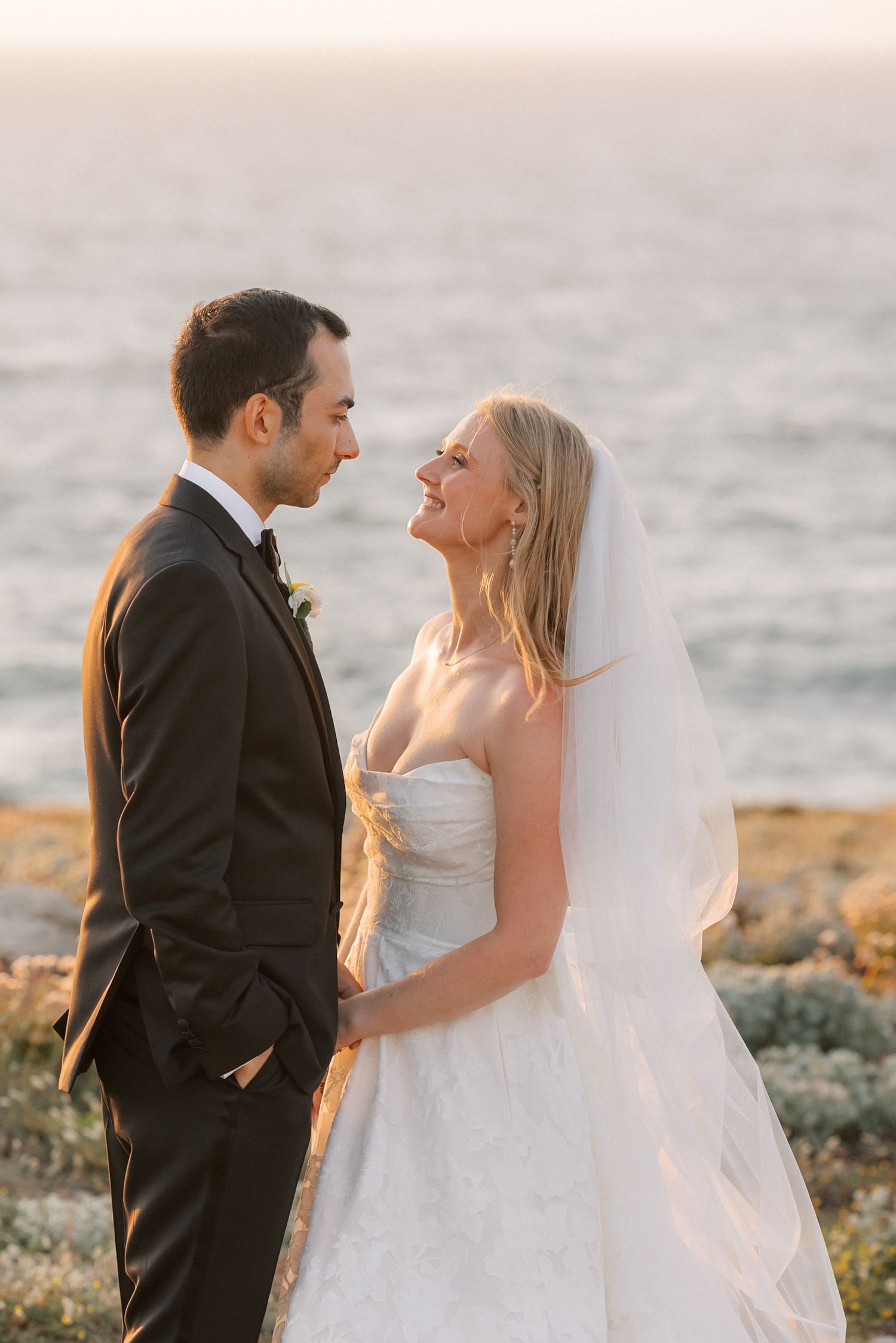Romantic sunset portrait of the bride and groom overlooking the Atlantic Ocean after their wedding ceremony at Arriba by the Sea.