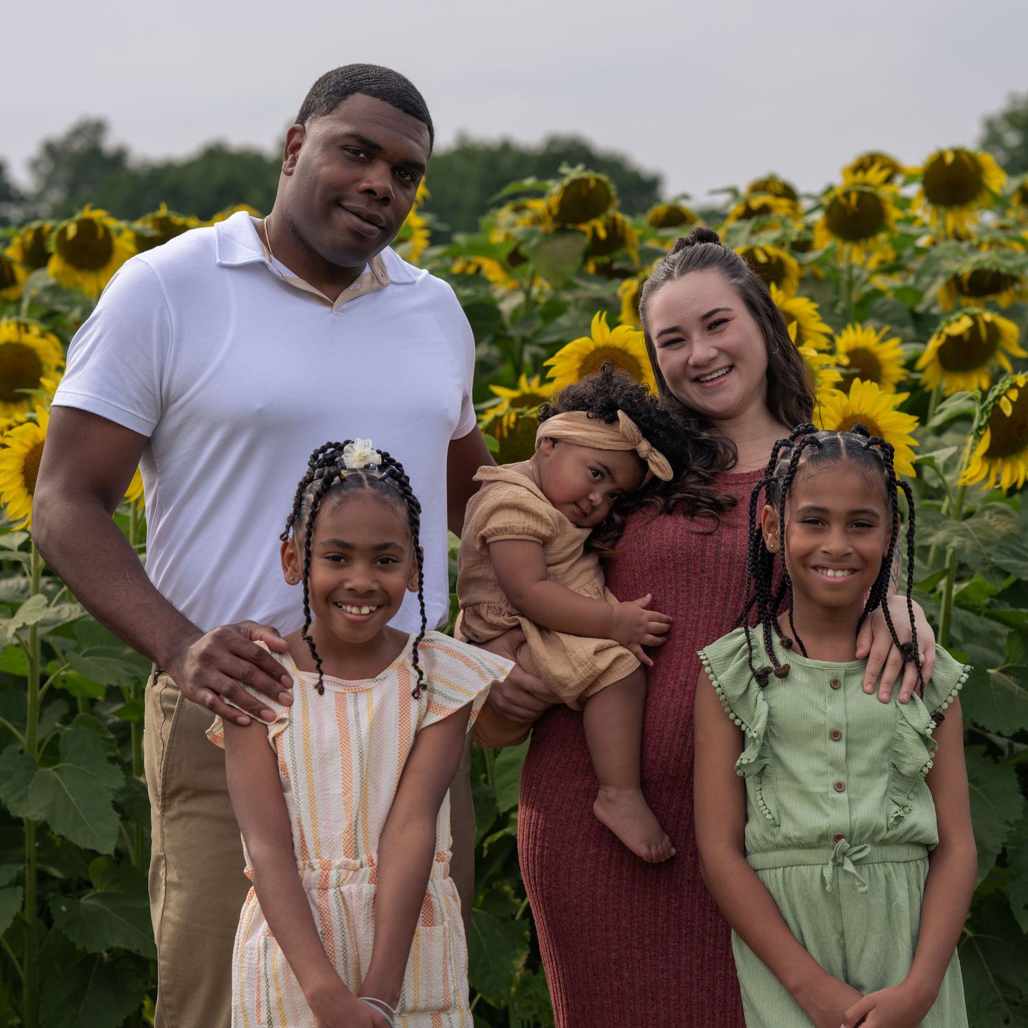 Family of five posing in a sunflower field for New Hampshire sunflower mini sessions