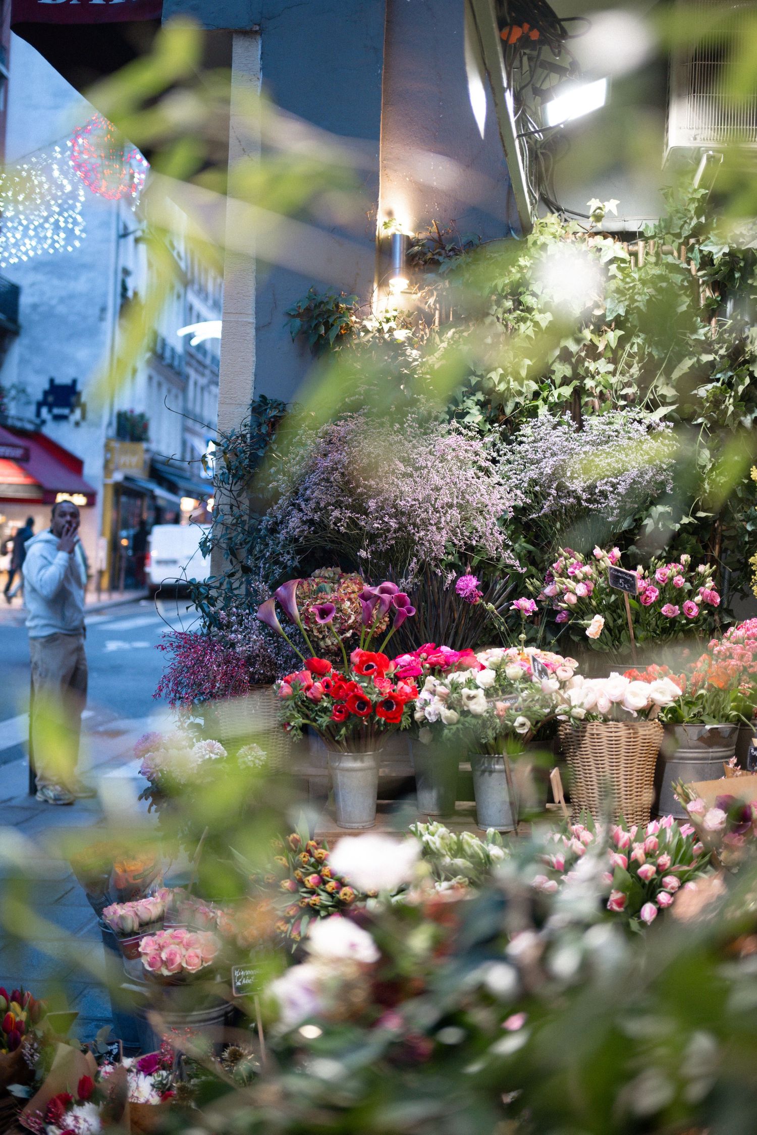 Vibrant floral market display showcasing colorful bouquets of fresh flowers in buckets under indoor lighting.