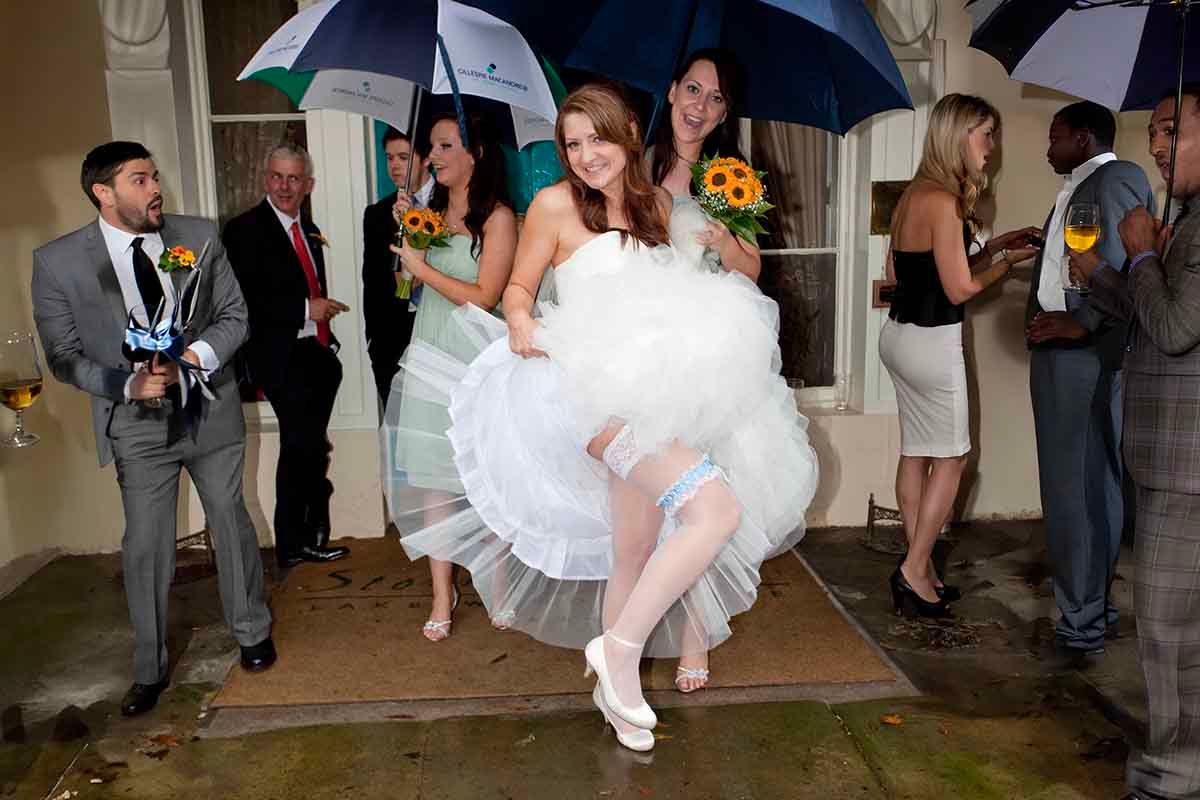 guests look on in amazement as the bride shows her garter on her wedding day