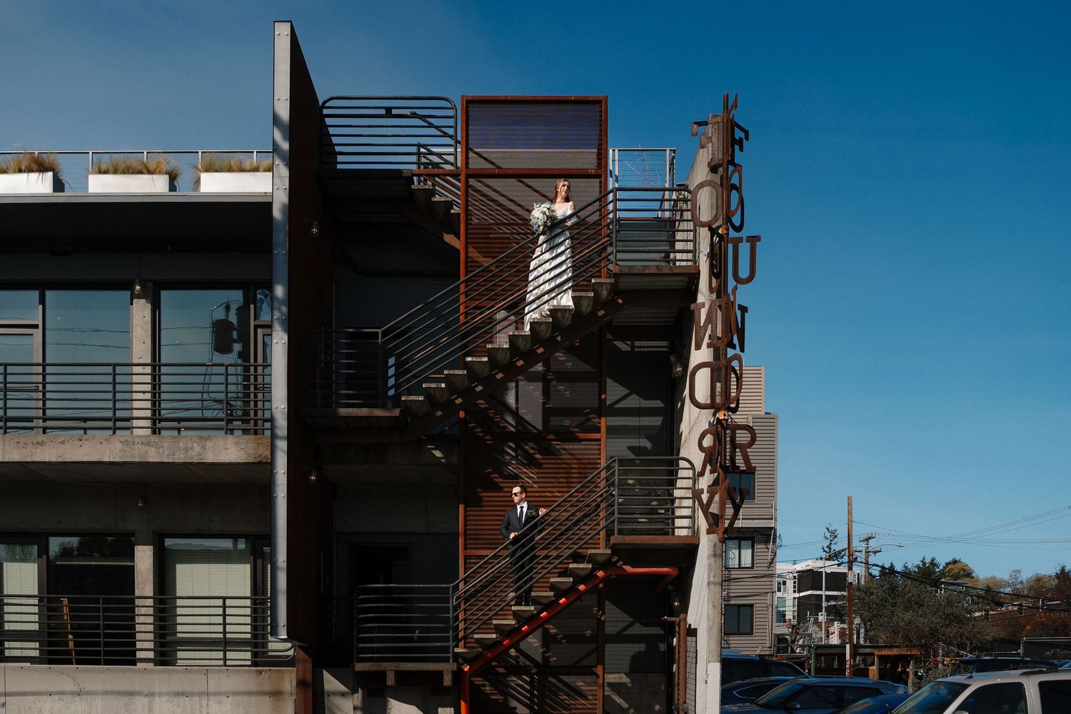 Serina and Mikey pose dramatically outside the Fremont Foundry for their city wedding.