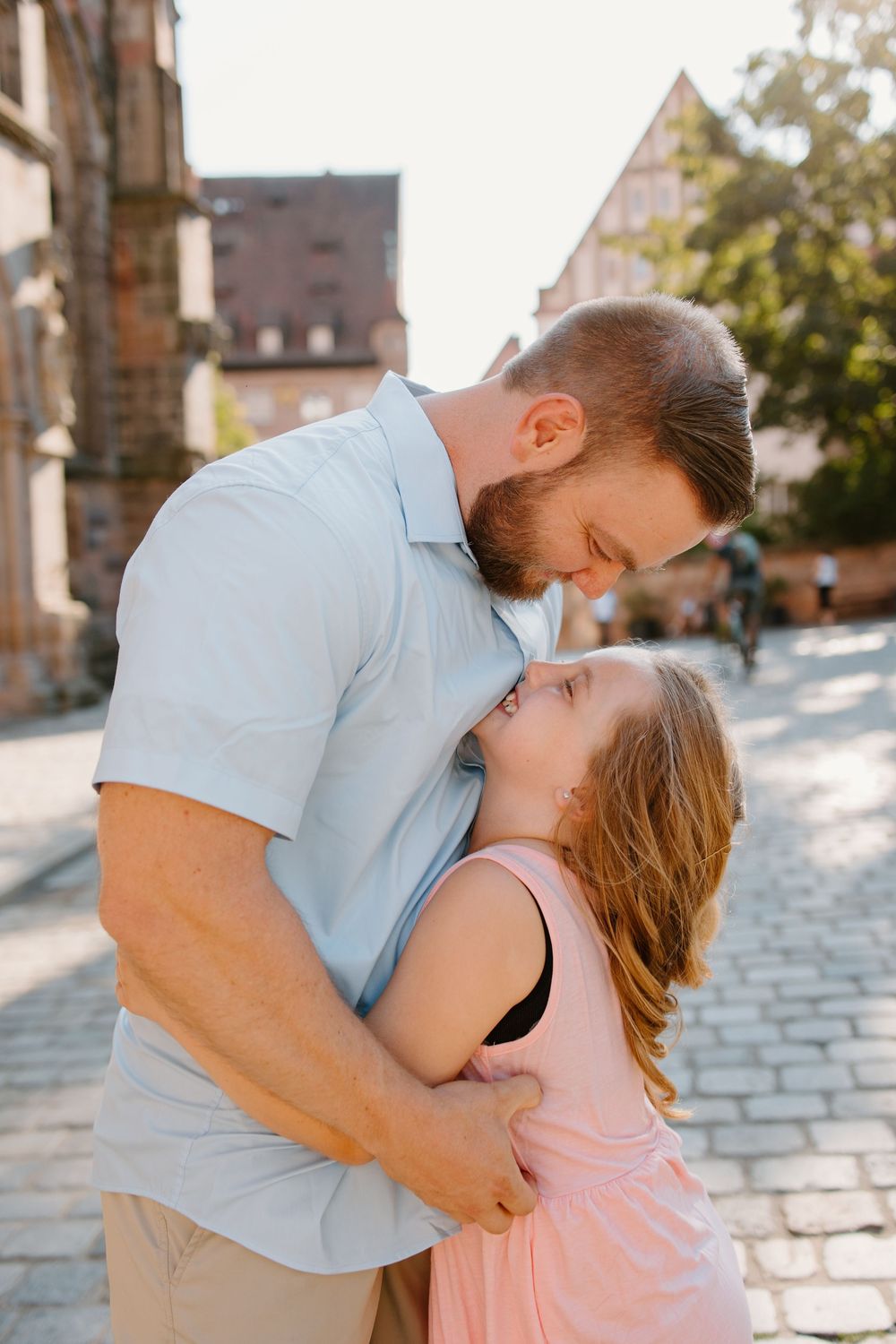 Family hugging and smiling during Nuremberg family photoshoot at St. Seebaldkirche