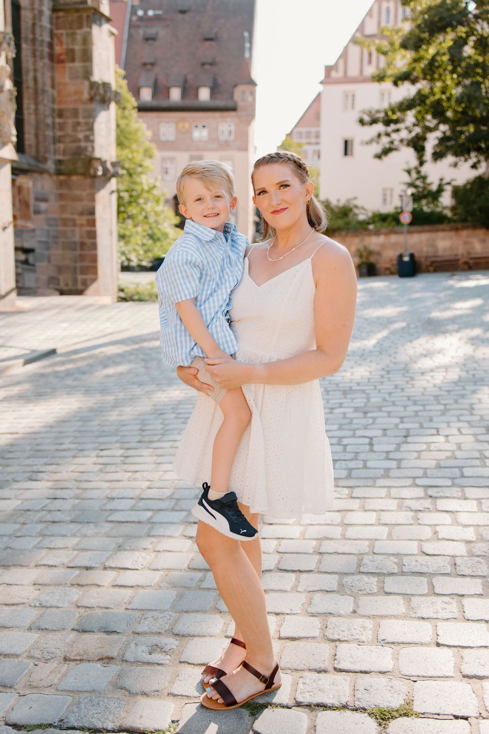 Family hugging and smiling during Nuremberg family photoshoot at St. Seebaldkirche