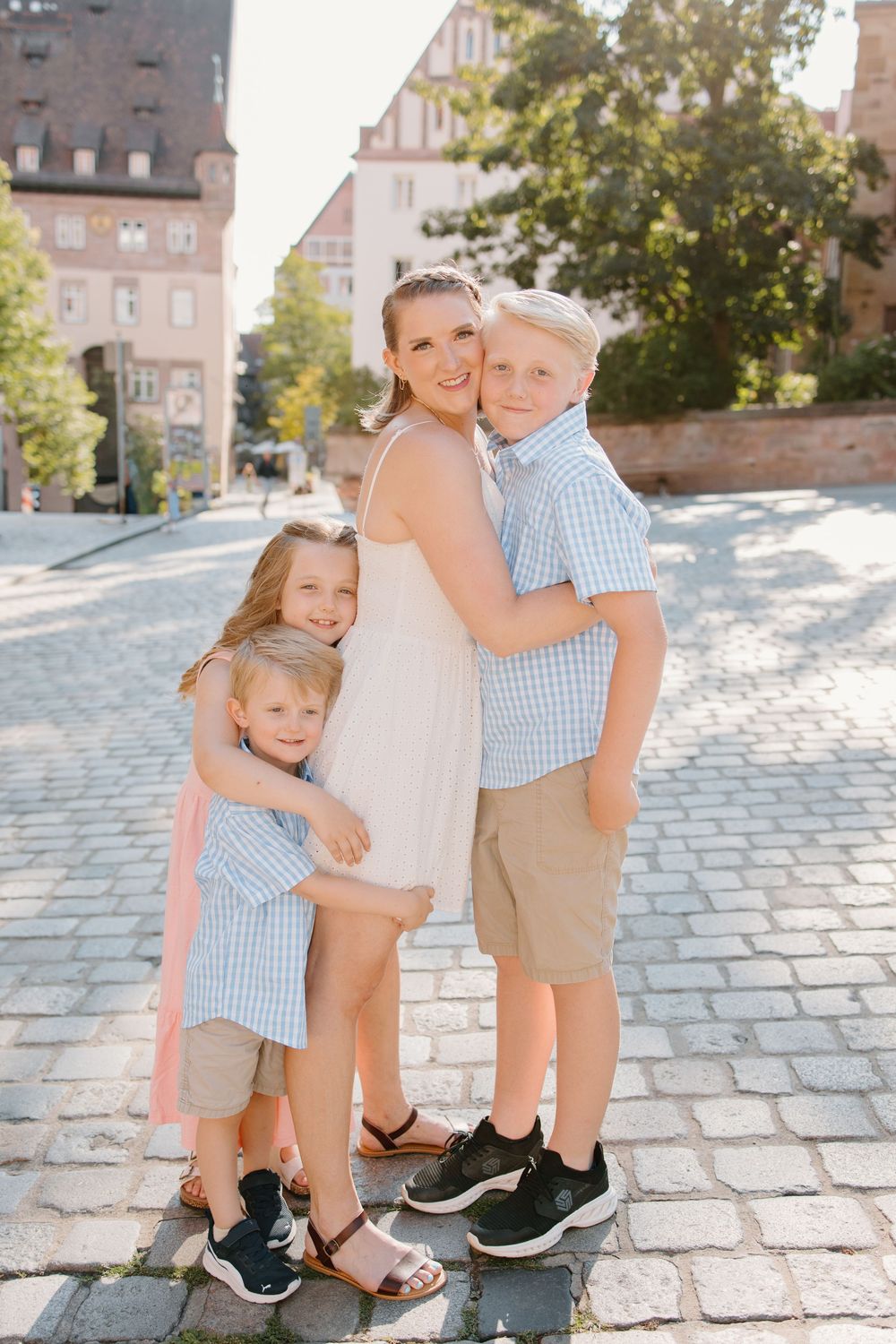 Family hugging and smiling during Nuremberg family photoshoot at St. Seebaldkirche