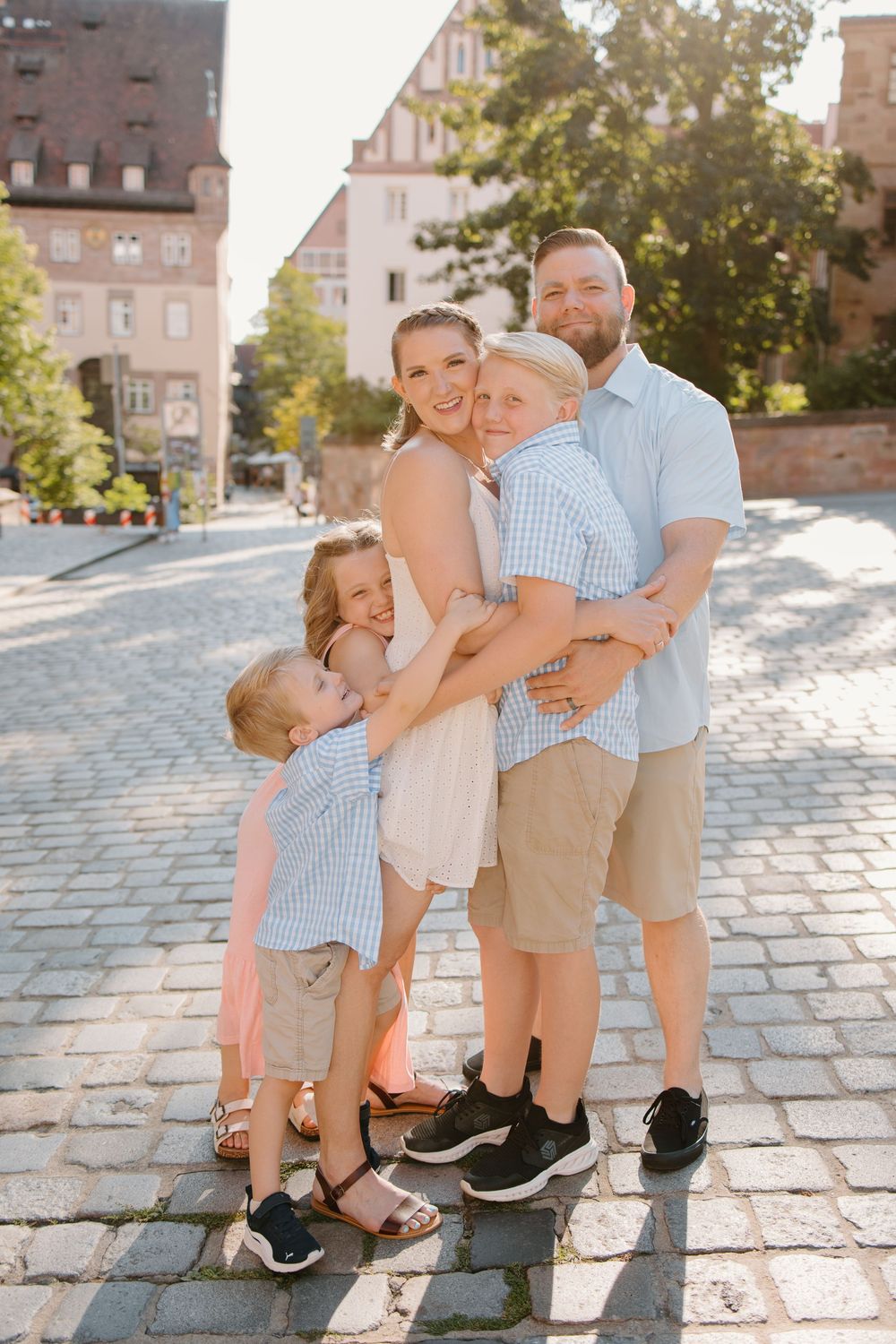 Family hugging and smiling during Nuremberg family photoshoot at St. Seebaldkirche