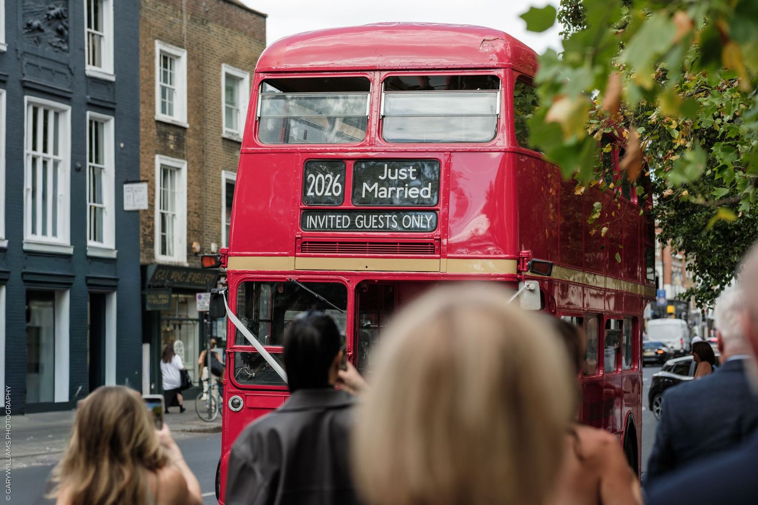 A vintage red double-decker London bus decorated with a Just Married sign for a wedding celebration.