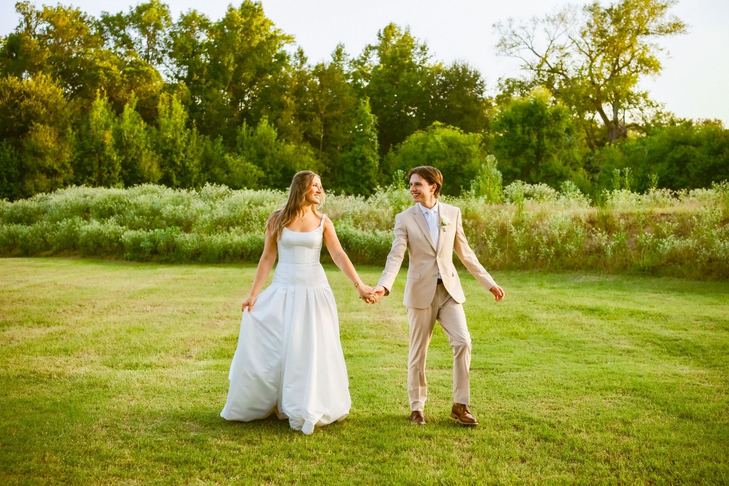 Blurred motion photo of a bride and groom kissing surrounded by bridesmaids in red and blue dresses at an outdoor wedding.