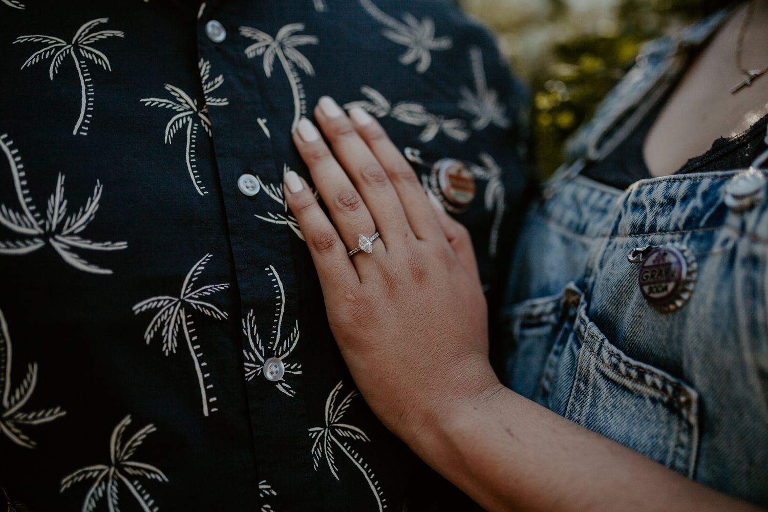 A woman places her hand on her husband's chest showing her engagement ring.