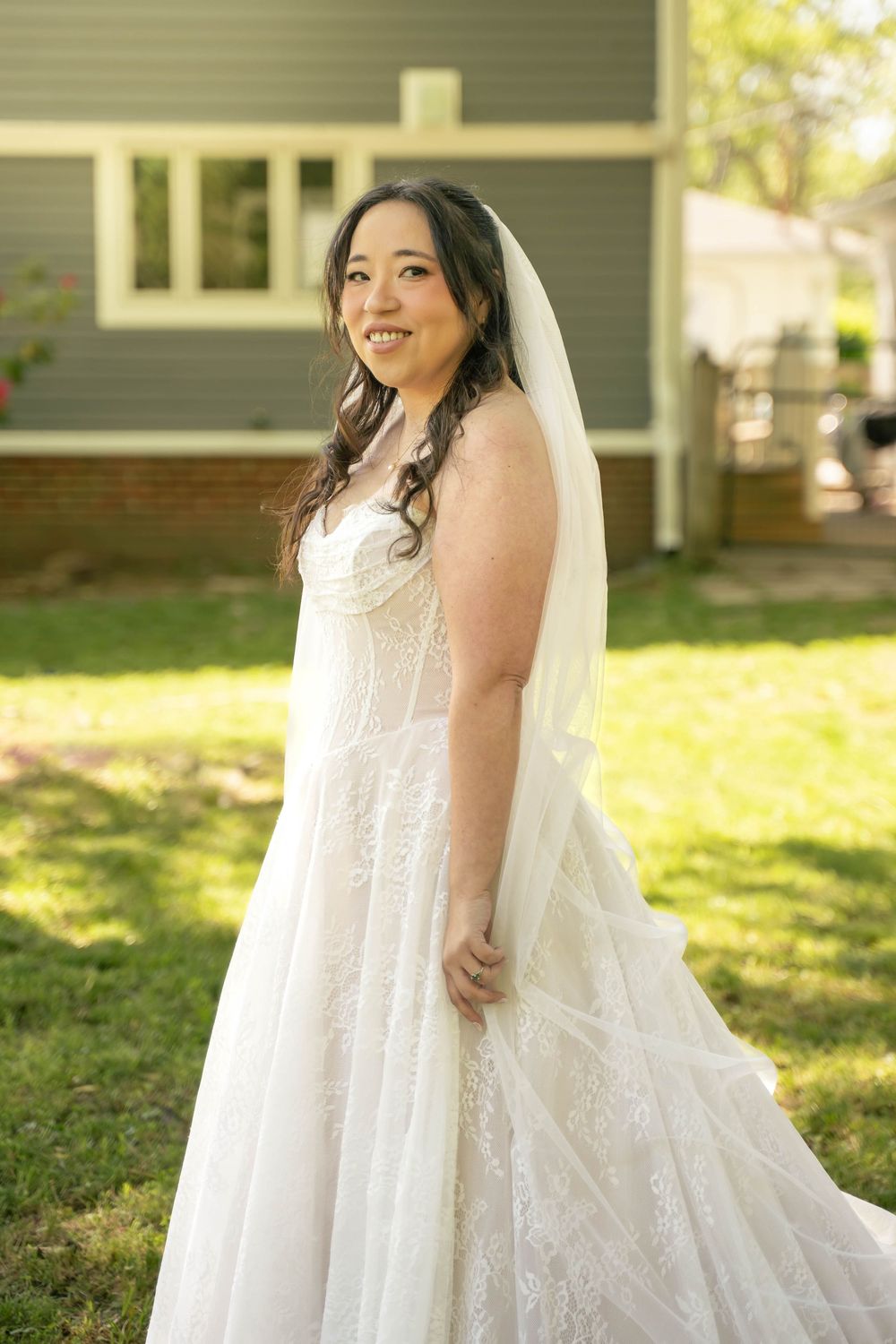 Bridal portrait, bride is wearing a delicate lace gown and veil