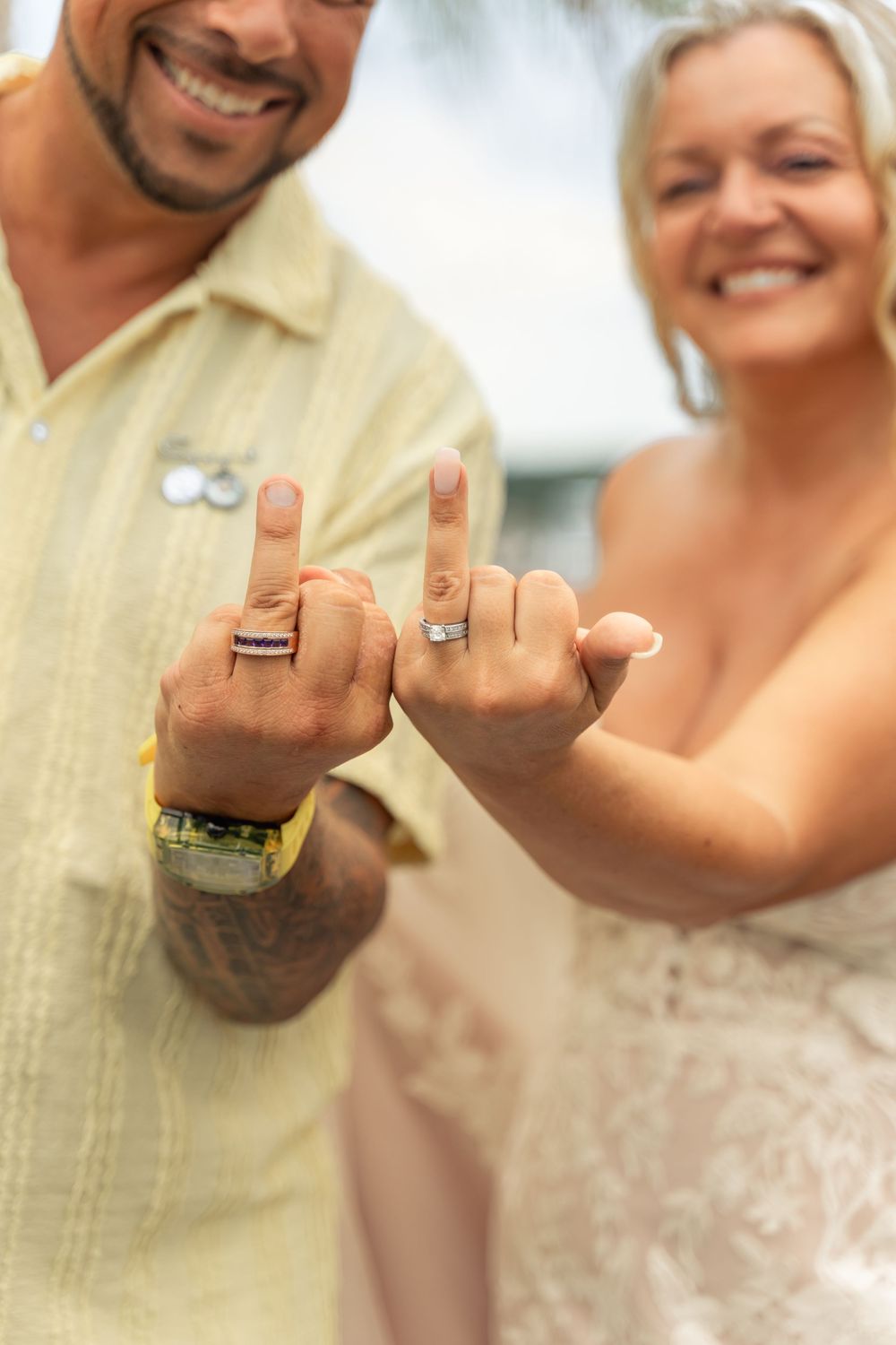 Bride and groom portrait holding up ring fingers