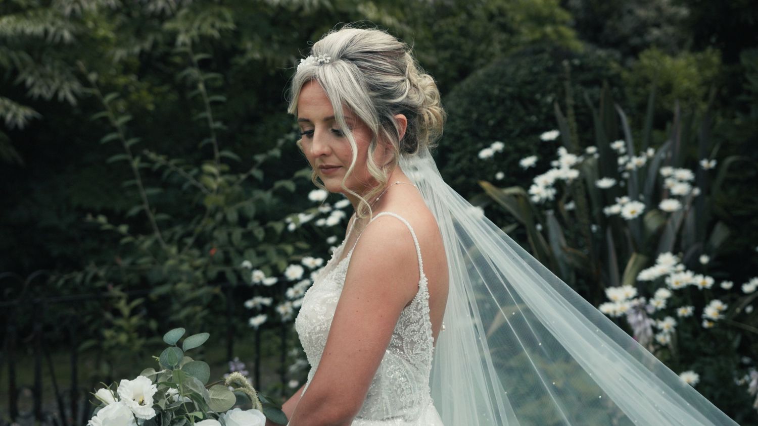 Bride standing in front of muted greenery at Ardwell Glasshouse, Dumfries and Galloway