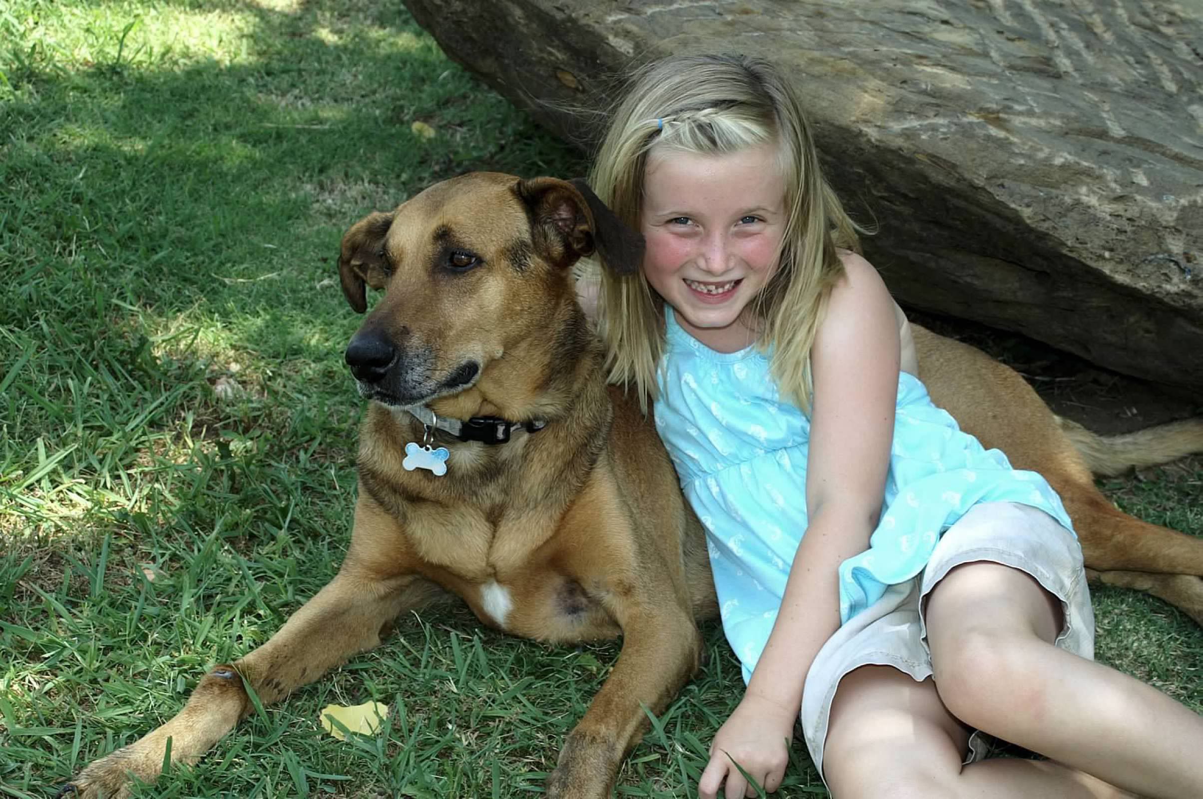 Young girl leaning on her dog