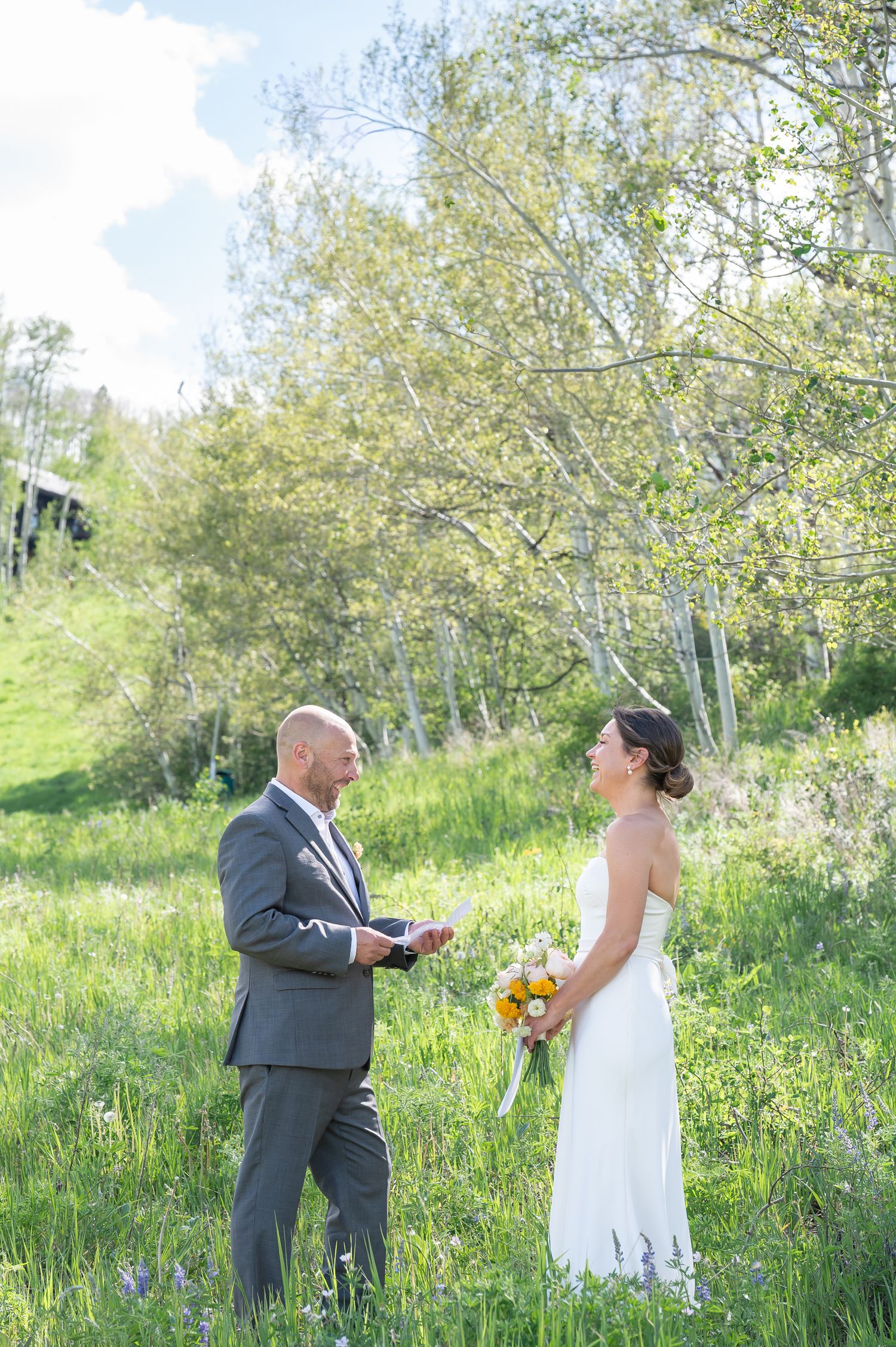 Colorado elopement with a beautiful couple standing in a field of wildflowers with aspen trees around them.