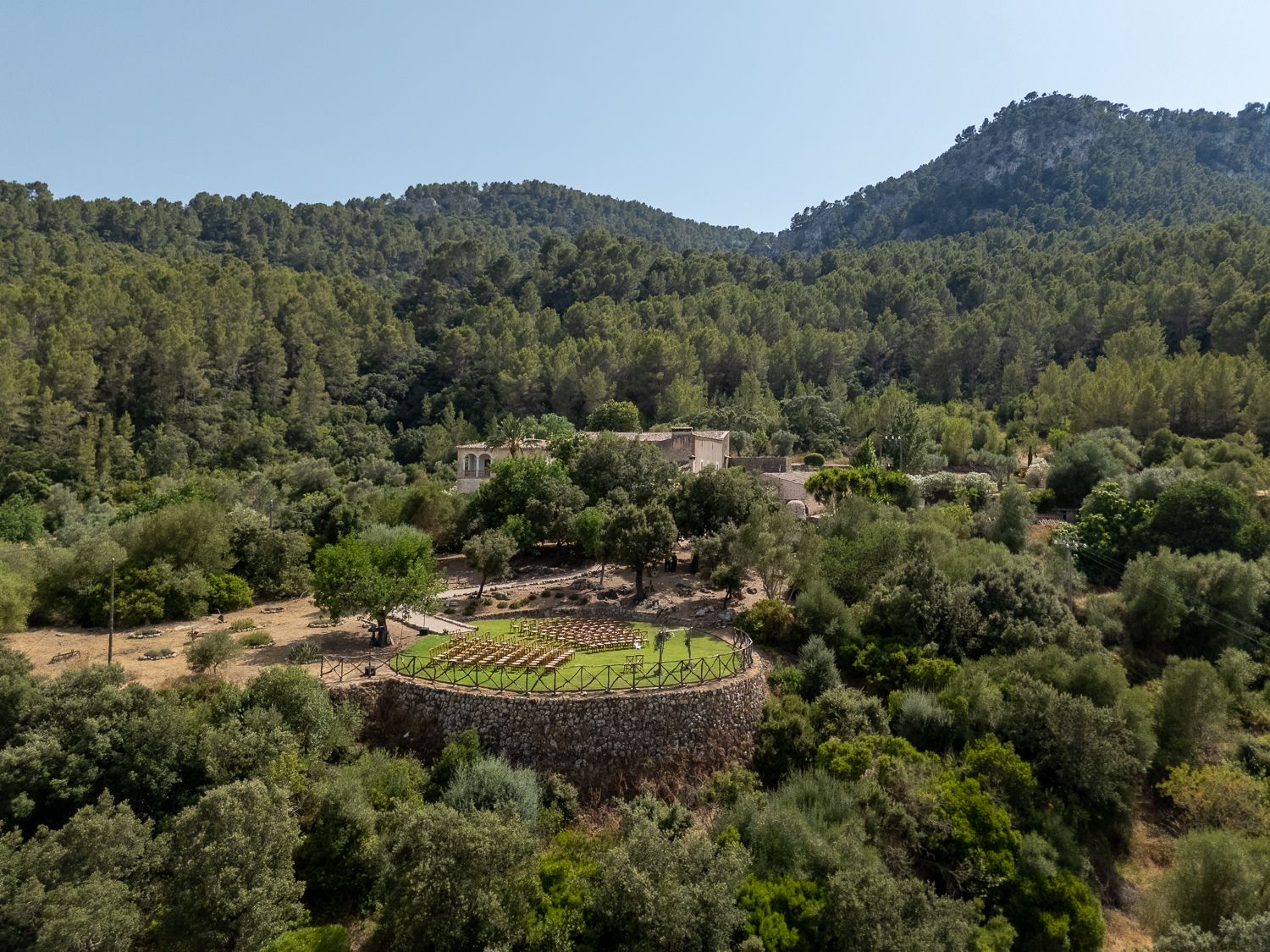 a typical mallorcan finca Son Burguet surrounded by the mountains with an intimate wedding ceremony set up in front of it
