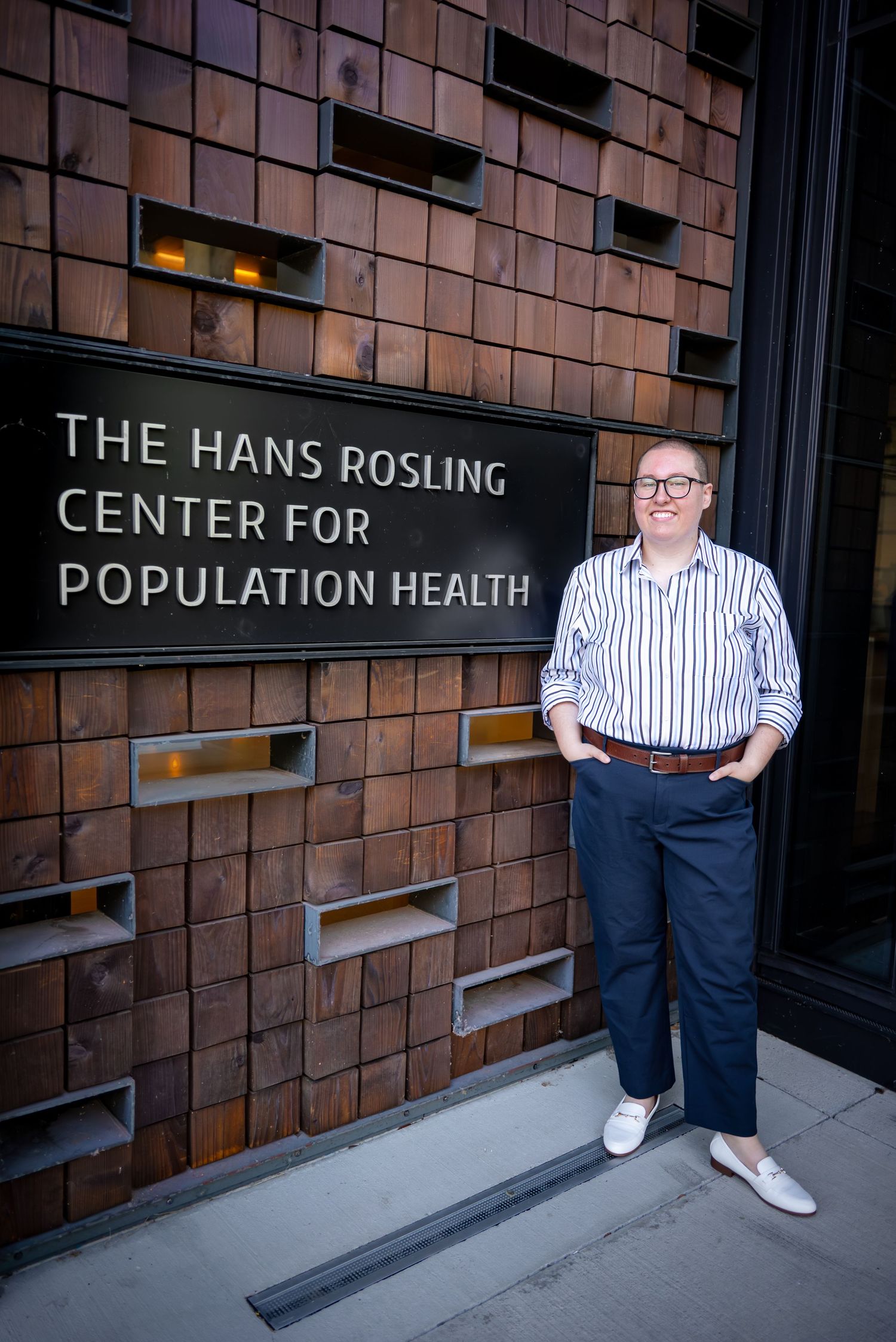 Graduate posing outside the Hans Rosling Center for Population Health at the University of Washington.