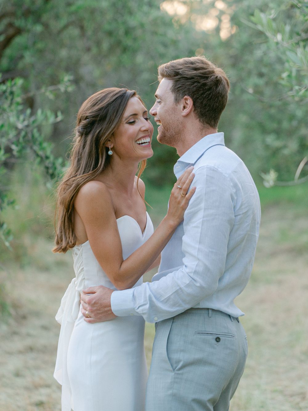 Candid moment of a couple laughing together during their wedding photoshoot.