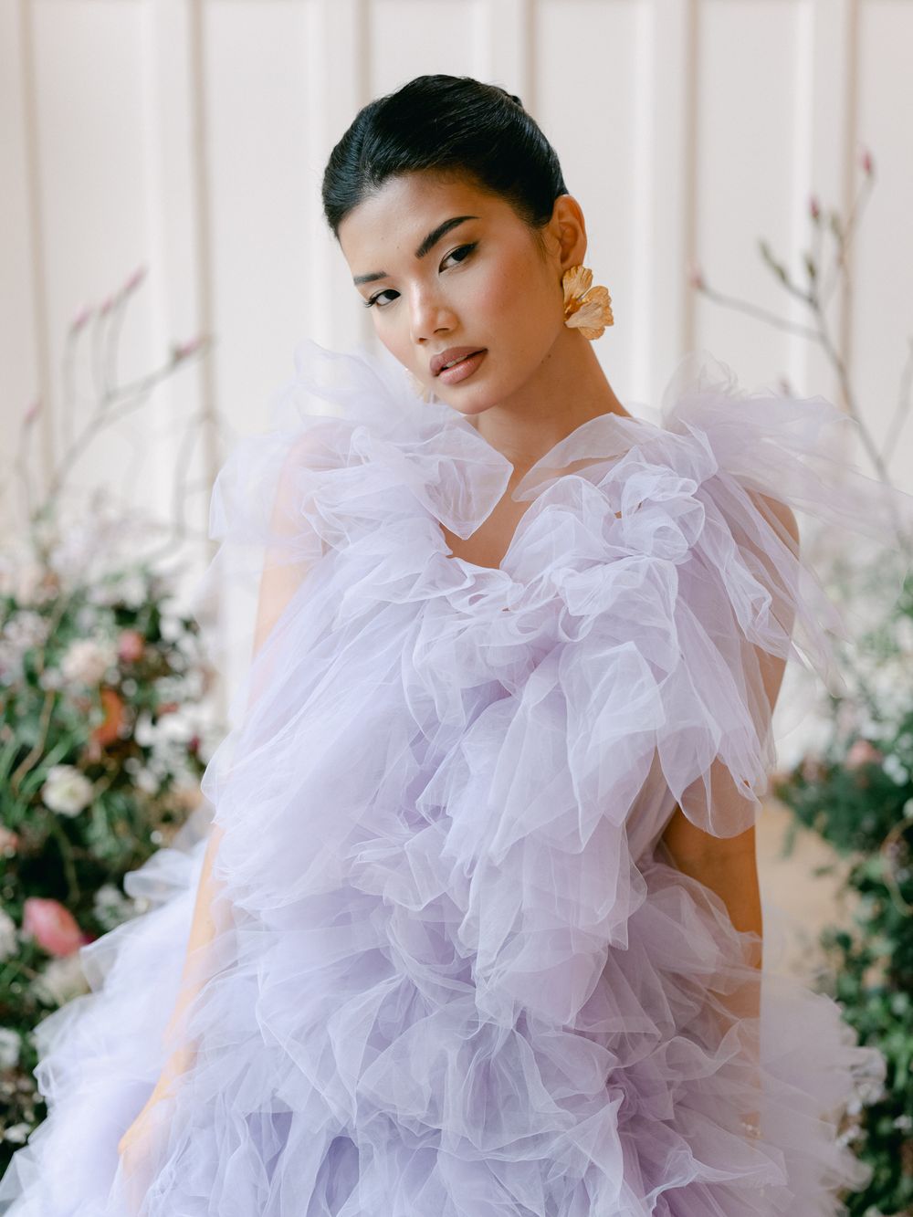 Fashion model wearing a dramatic lavender tulle gown with ruffled details.