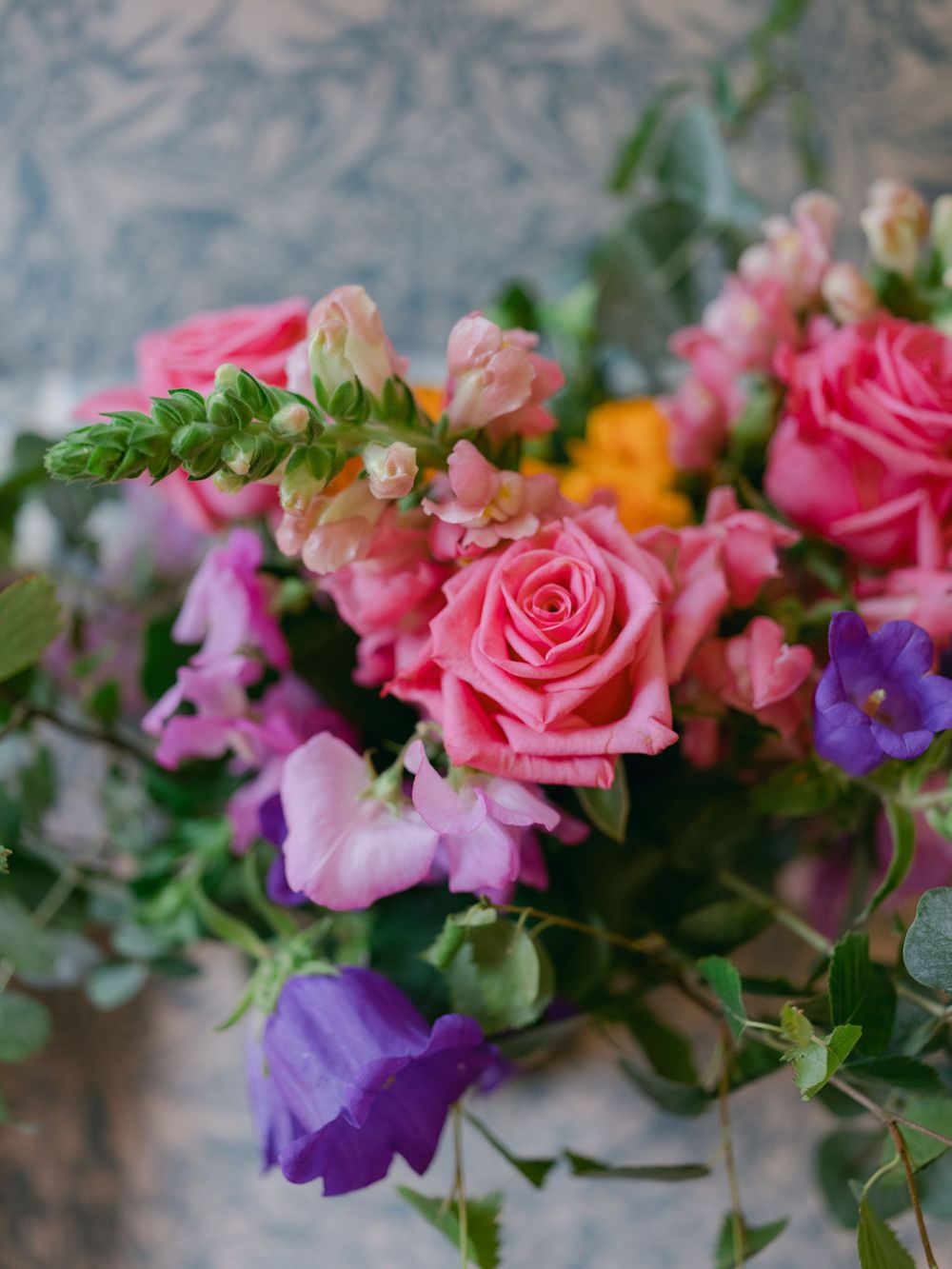 Vibrant floral arrangement featuring pink roses and purple blooms with greenery.