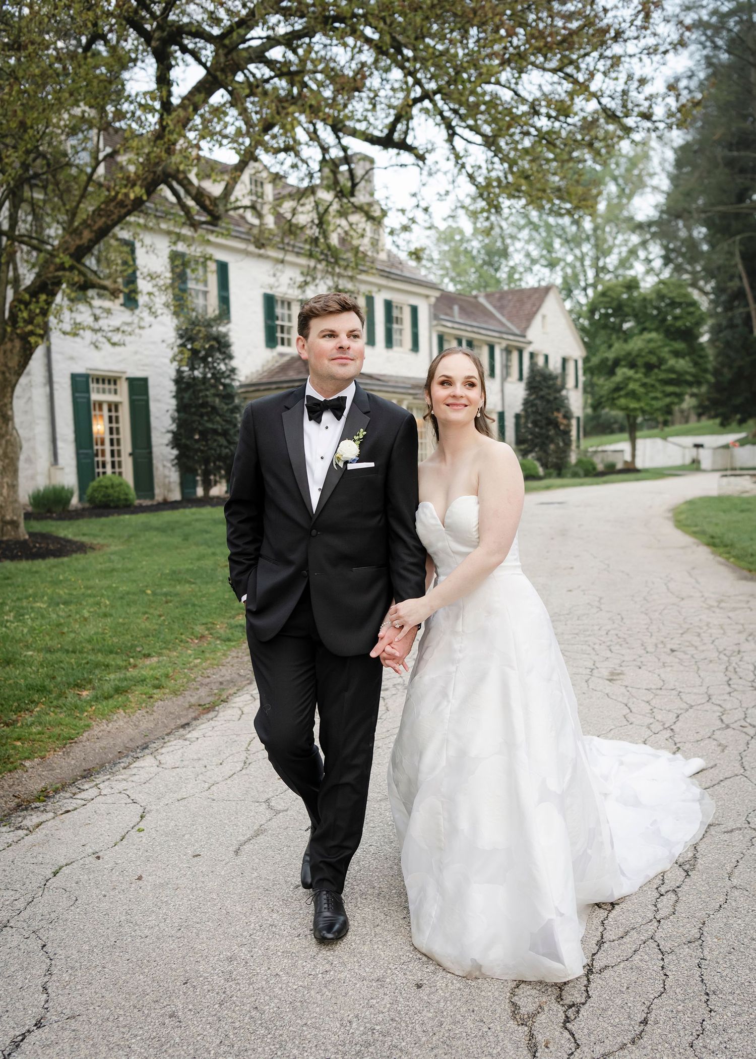 Bride and groom walk hand-in-hand outside elegant Philander Chase Knox setate on their wedding day.