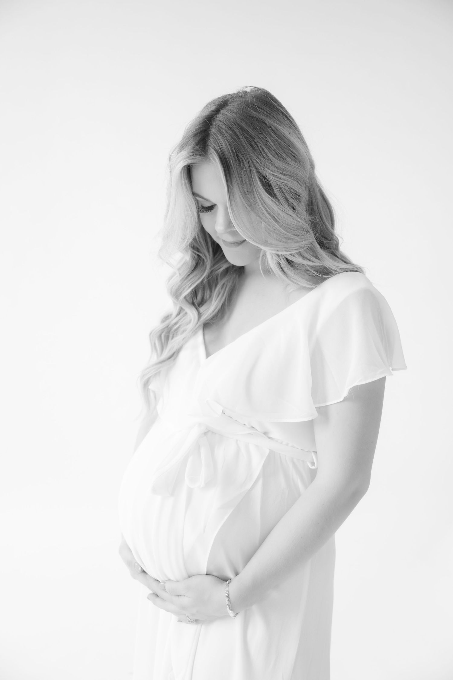 ethereal portrait of pregnant mom holding her baby bump during in studio maternity session in stillwater mn with jagger rose photography