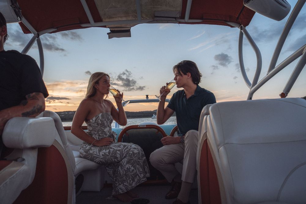 Couple enjoying champagne together on a luxury boat during a beautiful sunset cruise.